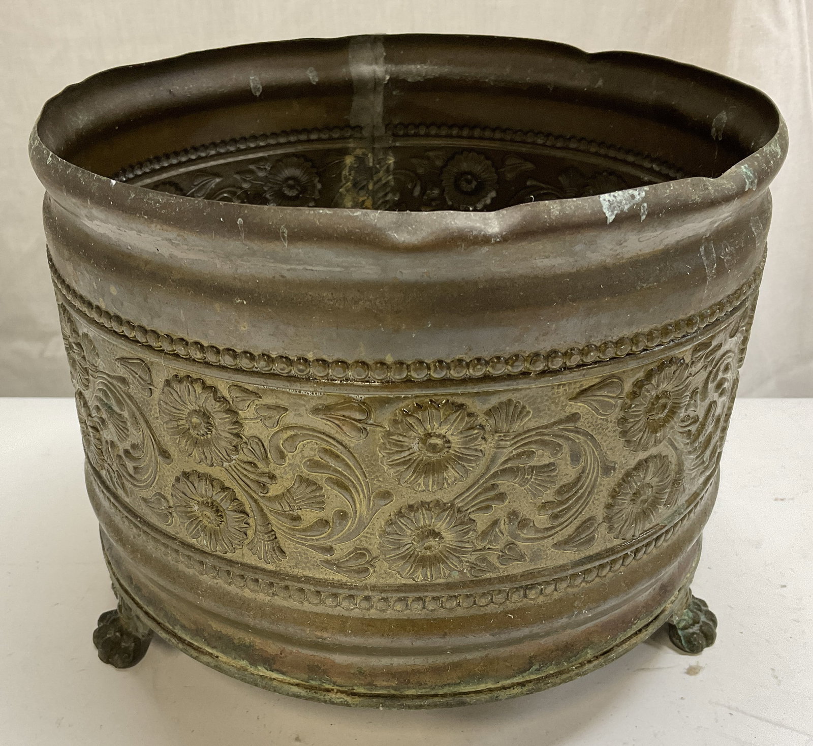 Vintage Embossed Floral Motif Brass Planter: Vintage Embossed Floral Motif Brass Planter. Clawed Feet. Surface Wear Including Green Patina, Bending, and Scratching. Measures app 6in H x 7.5in Diam. Vintage Planter, Embossed Florals, Engraved