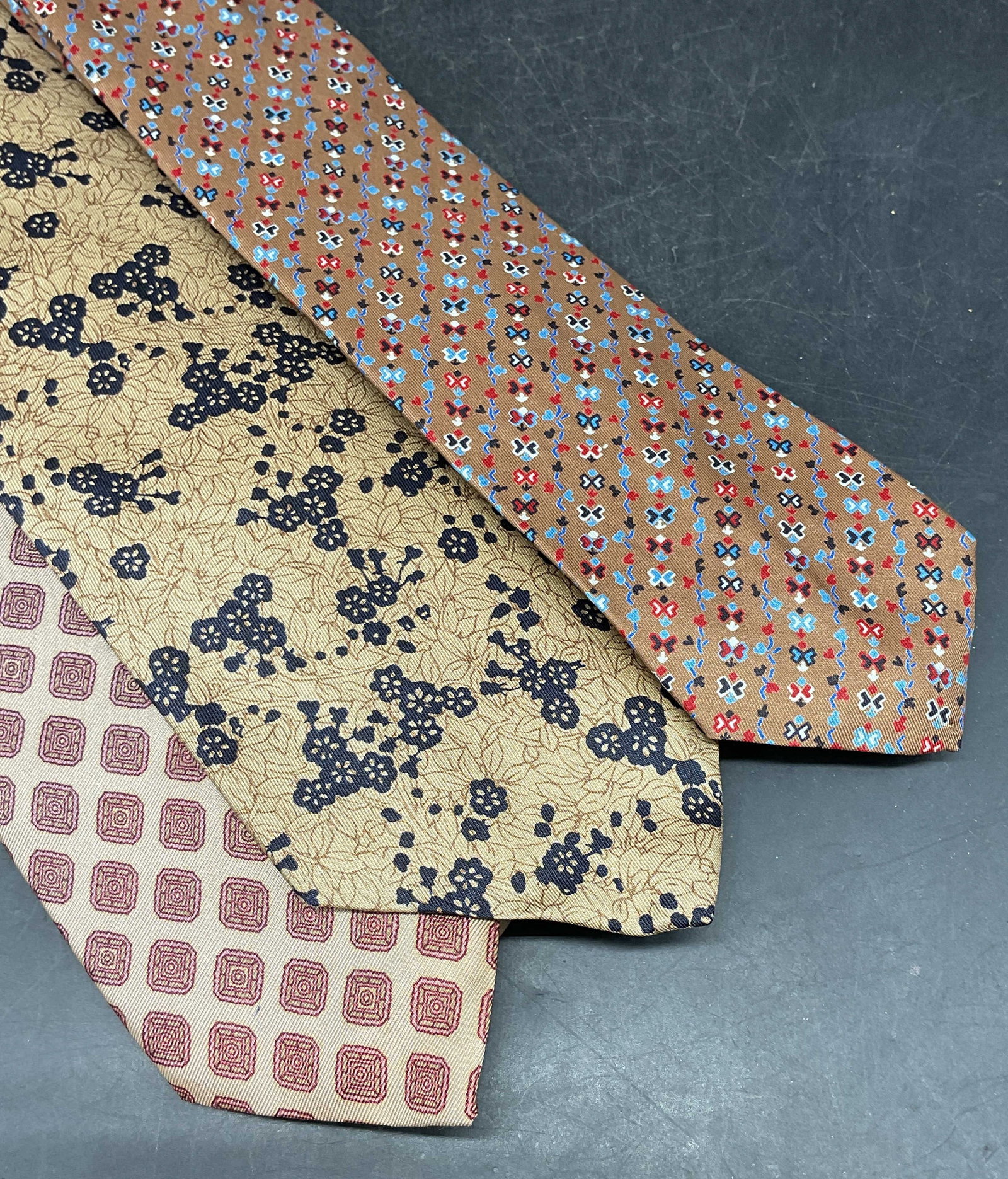 Lot 3 Pierre Cardin & More Printed Silk Ties: Lot of 3 vintage ties. Pierre Cardin brown butterfly print silk tie. May D & F tan floral print silk tie. Bancroft tan geometric print acetate tie. Longest approx 56 inches. Some blemishes. Tie, silk 