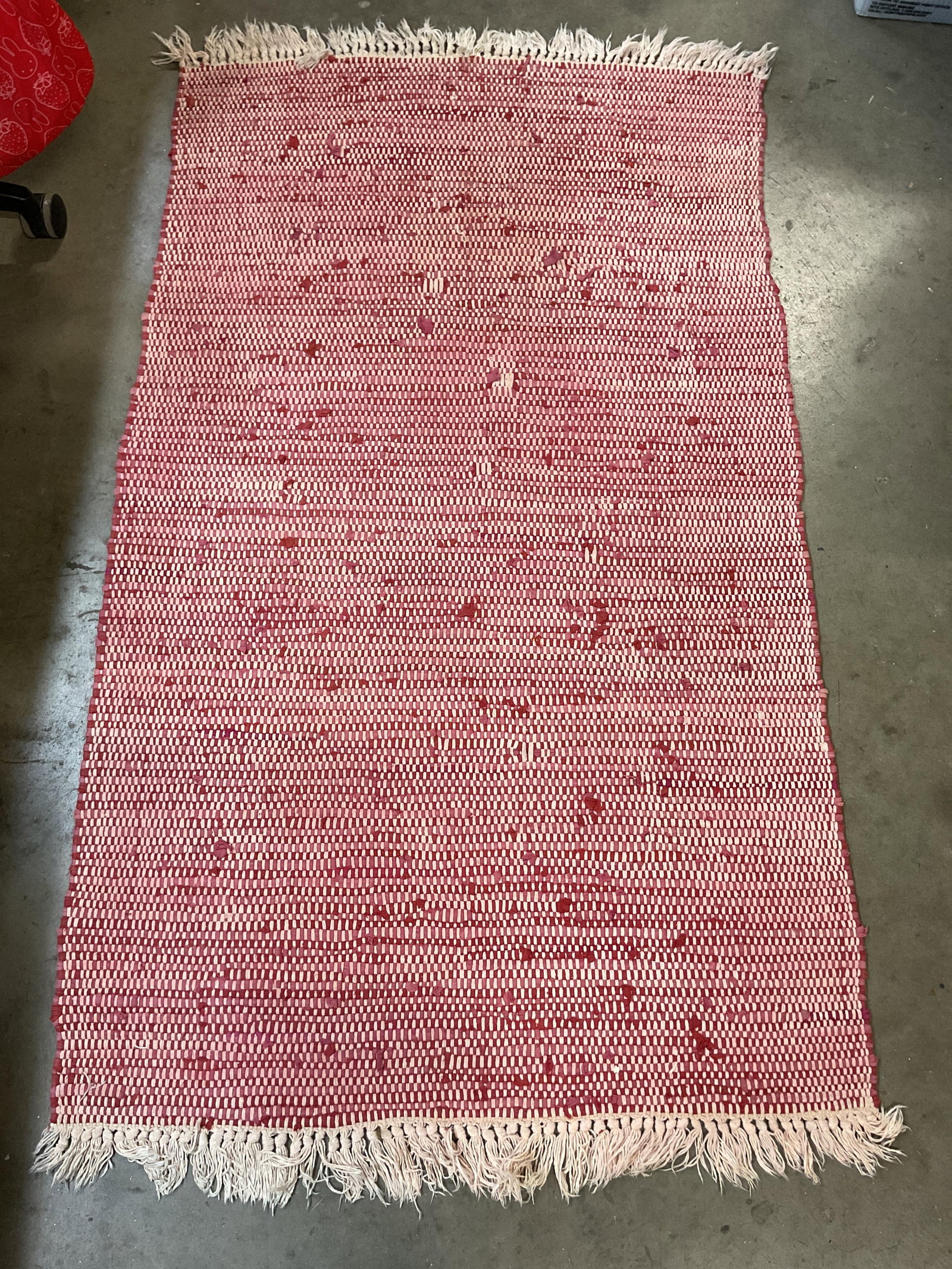 Hand Made Wool Fringed Red & White Rug 64in: Hand made wool fringed red and white rug. White fringed trim. Red and white geometric pattern. Measures approx 37 x 64 inches. Surface wear consistent with exposure. Rug, hand made rug, carpets, home 