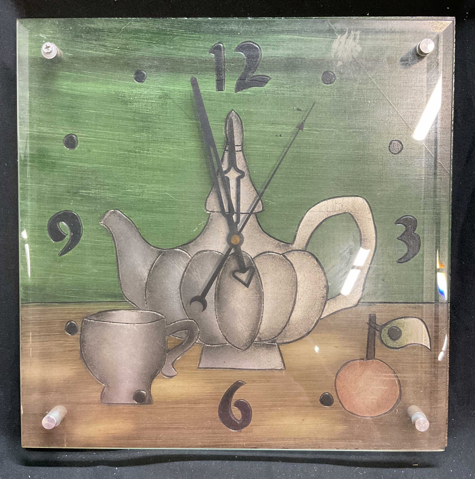 Vntg Style Decorative Teapot Glass Wall Clock: This wall clock has a painted design of a silvery teapot with a matching tea cup on a table surface, has glass overlay, stylized painted number, measures ht 12 inches width app 11.5 inches, depth as