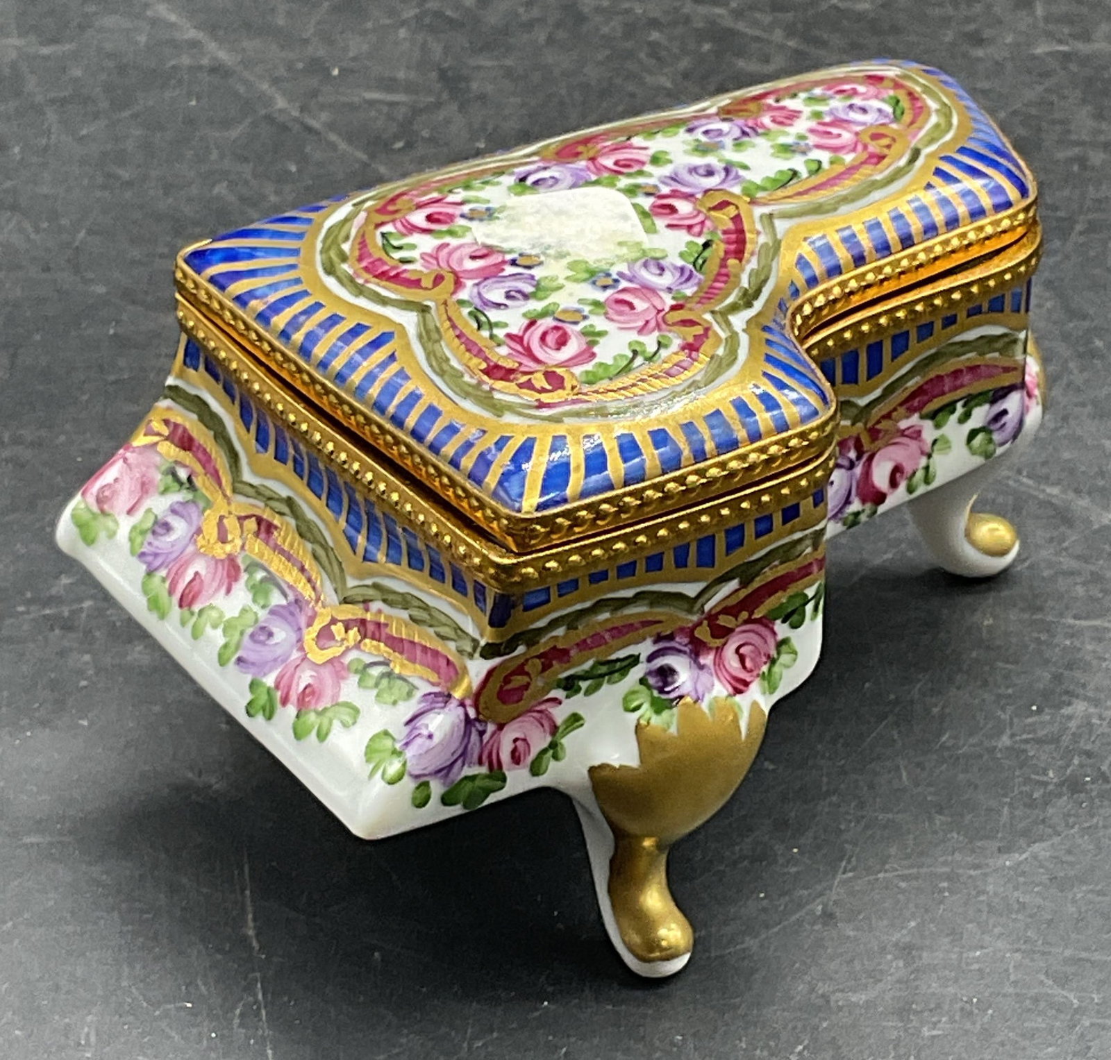 Limoges Porcelain Grand Piano Trinket Box France: Vintage Limoges porcelain grand piano trinket box. Hand painted and gilt with floral motifs. Made in France. Measures approx. 3.5 x 2 x 1.75 inches. Interior hardware needs repair. Some scratching. Li