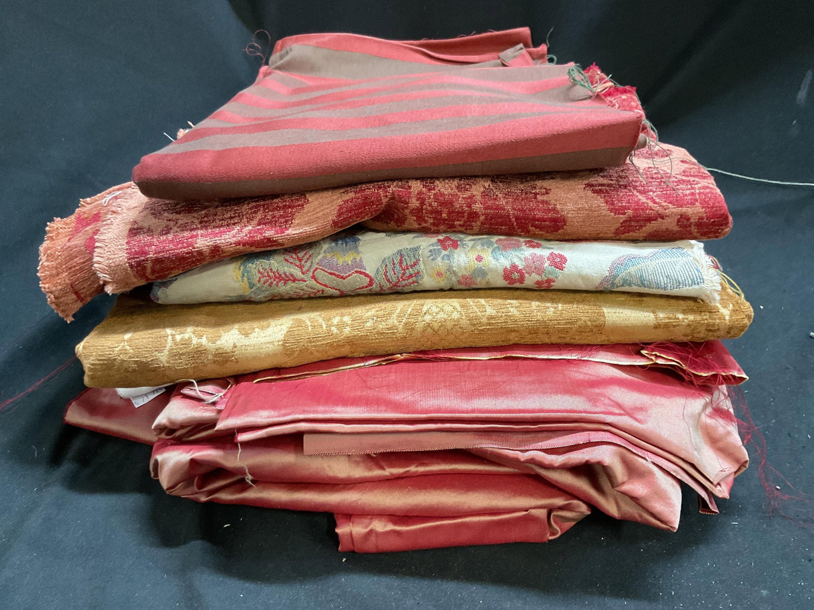 Group Lot Silk, velvet linen FBRIC PIECES: Yardage, scraps and pieces of red toned and more fabric pieces, not measured , property of Manhattan interior designer estate, bulk