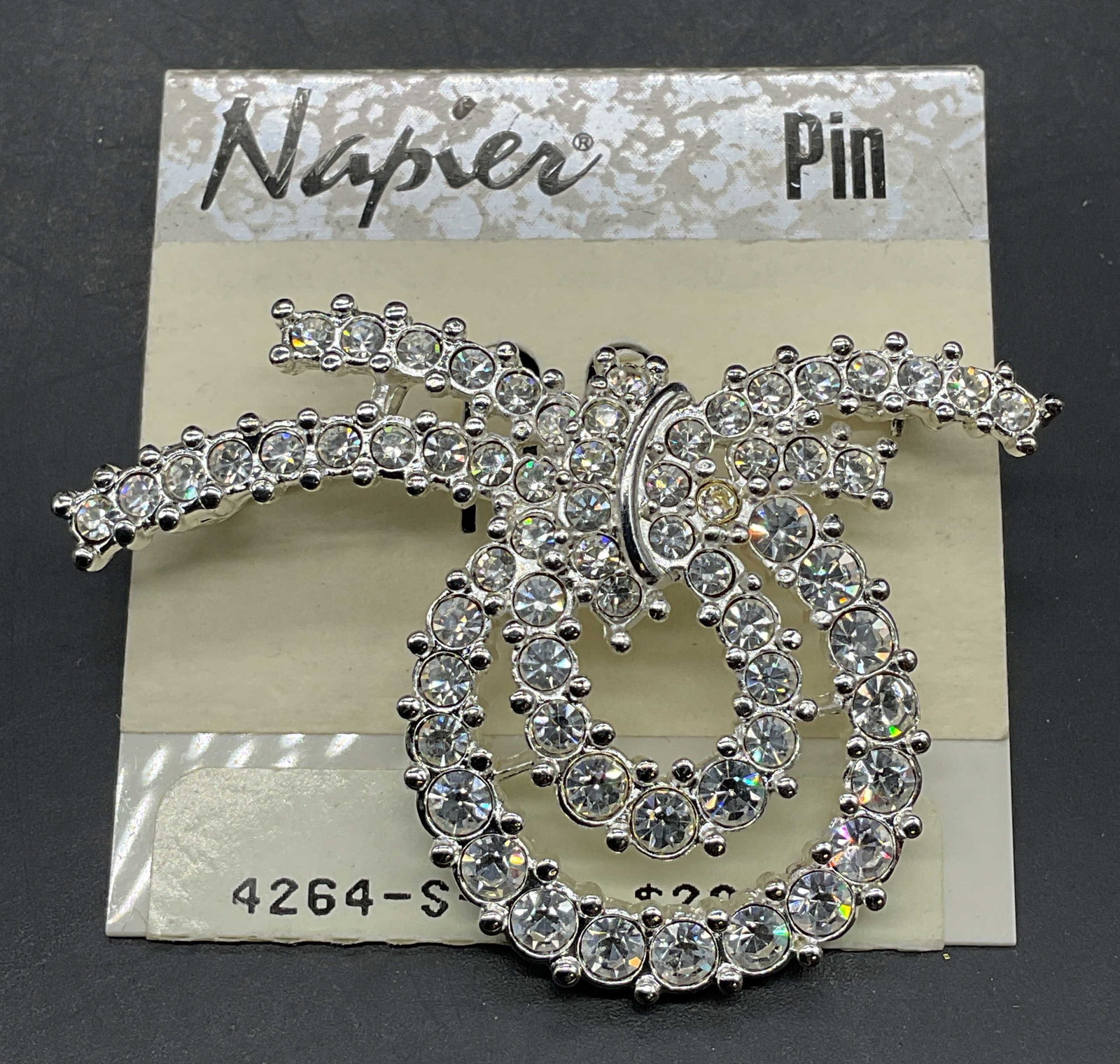 Vintage Napier Silver Tone Crystal Brooch NWT: Vintage Napier silver tone and crystal ribbon brooch. Measures approx. 2.25 x 1.5 inches. New with tag. Some scratching. Jewelry, estate jewelry, costume jewelry, cocktail jewelry, fashion jewelry,