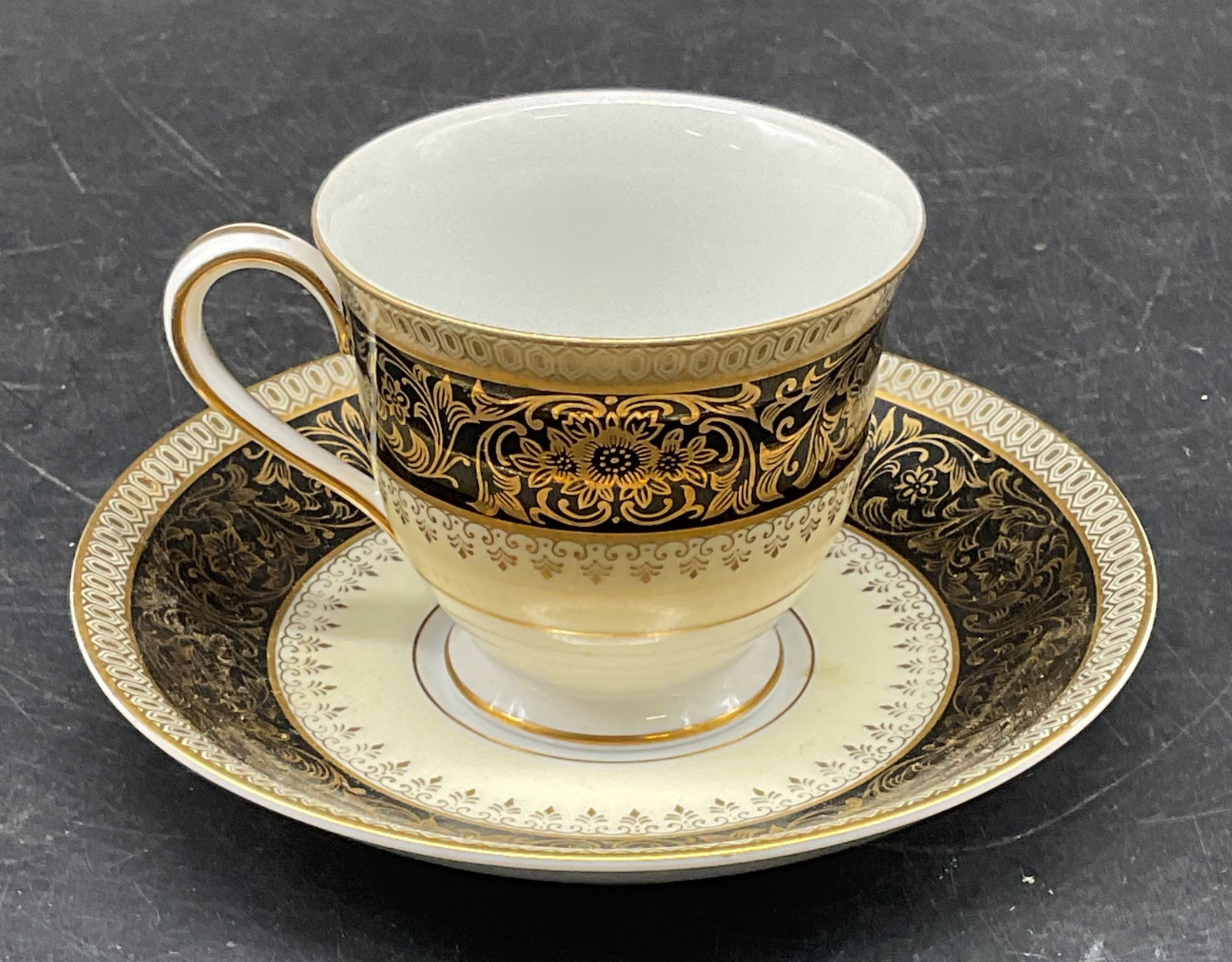 Vtg NORITAKE China Goldlea Teacup & Saucer: Vintage NORITAKE China teacup and saucer in Goldlea pattern. Gilt ornate scroll design. Made in Japan. Cup measures approx. 2.5 x 2.25 inches. Saucer measures approx. 4.75 inches wide. Some