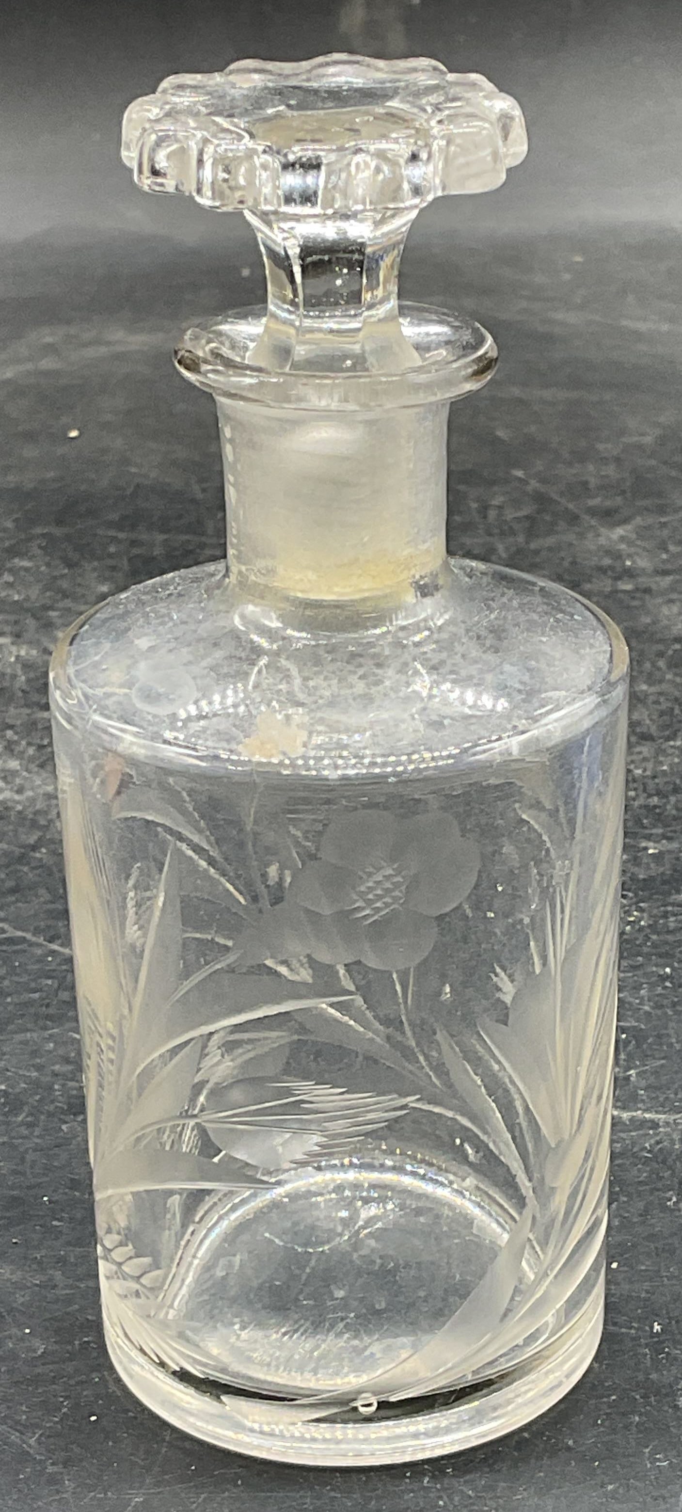 Vintage Etched Glass Floral Perfume Bottle: Vintage etched glass perfume bottle its floral motifs. Includes a stopper. Measures approx. 2.25 x 5 inches including stopper. Some scratching and small chips. Etched glass perfume bottle, floral