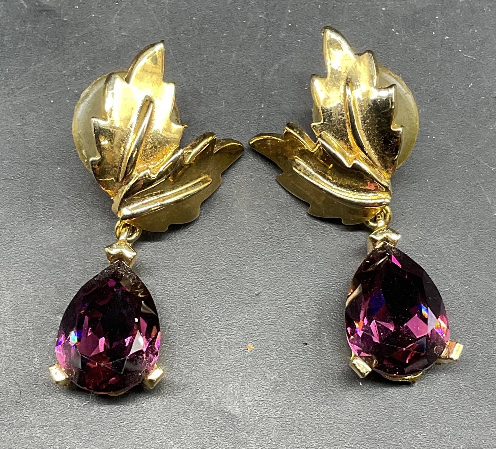 Vintage Gold Tn Purple Crystal Leaf Earrings: Vintage gold tone leaf motif earrings with purple crystals. Measures approx. 1.5 inches long. Some scratching. Jewelry, estate jewelry, costume jewelry, cocktail jewelry, fashion jewelry, accessories,