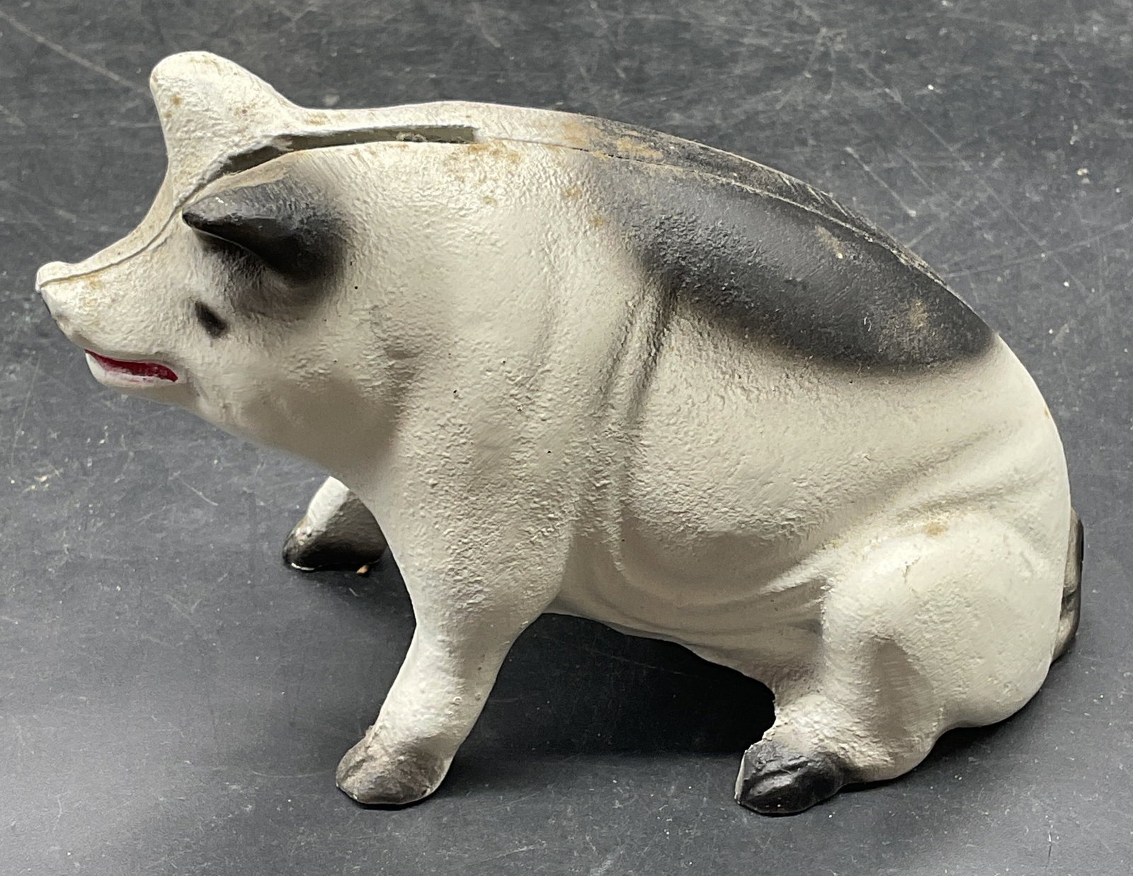 Cast Iron Black & White Pig Coin Bank: Cast iron black and white pig coin bank. Measures approx. 4.5 x 2 x 2.75 inches. Some scratching. Pig coin bank, piggy bank, iron coin bank, home decor, table decor, 10 s