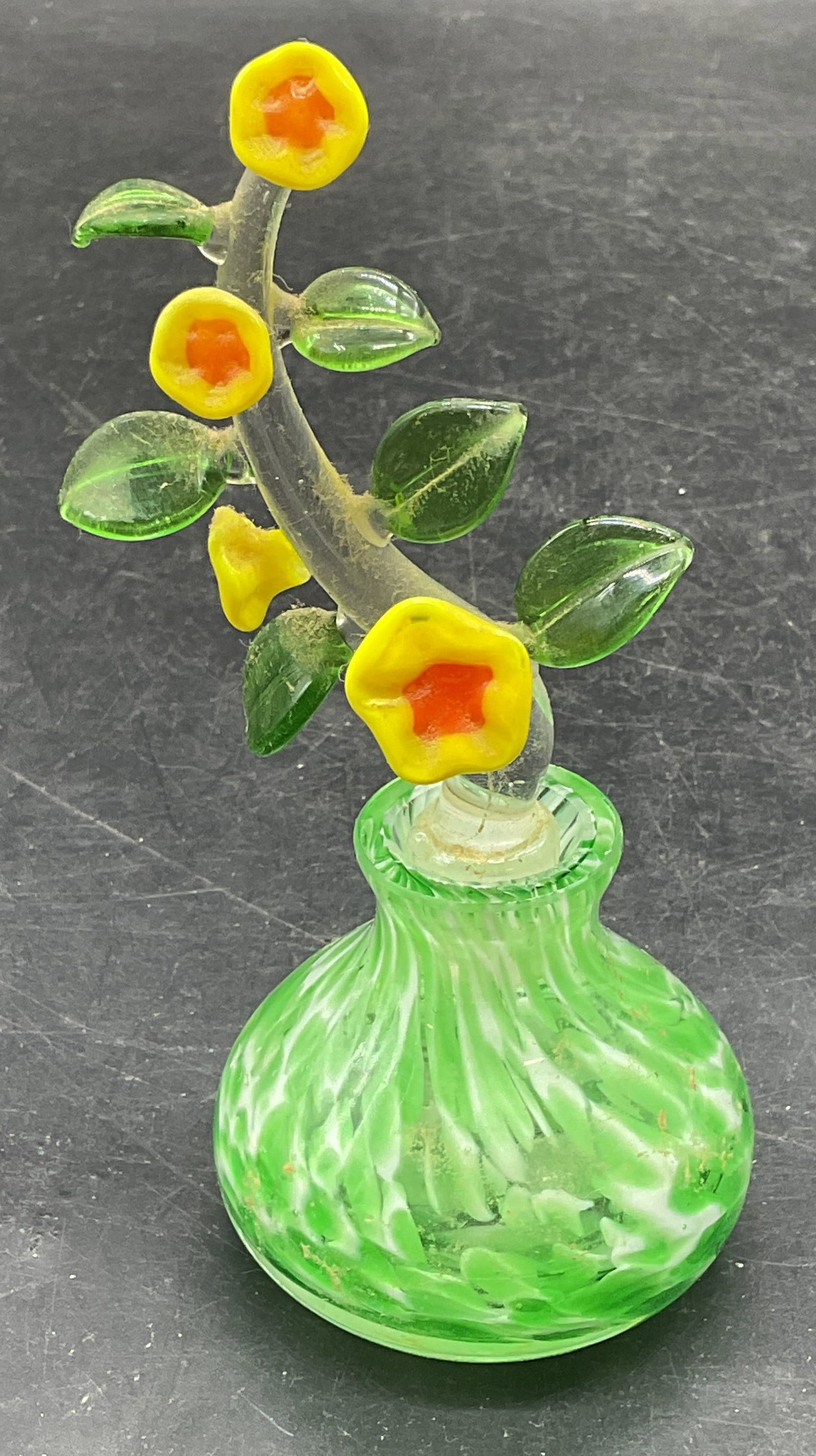 Green Art Glass Flower Perfume Bottle: Hand blown art glass perfume bottle with flower motif stopper. Mottled green. Measures approx. 2.25 x 2.25 inches. Stopper measures approx. 4.25 inches long. Some scratching and losses to stopper. Art