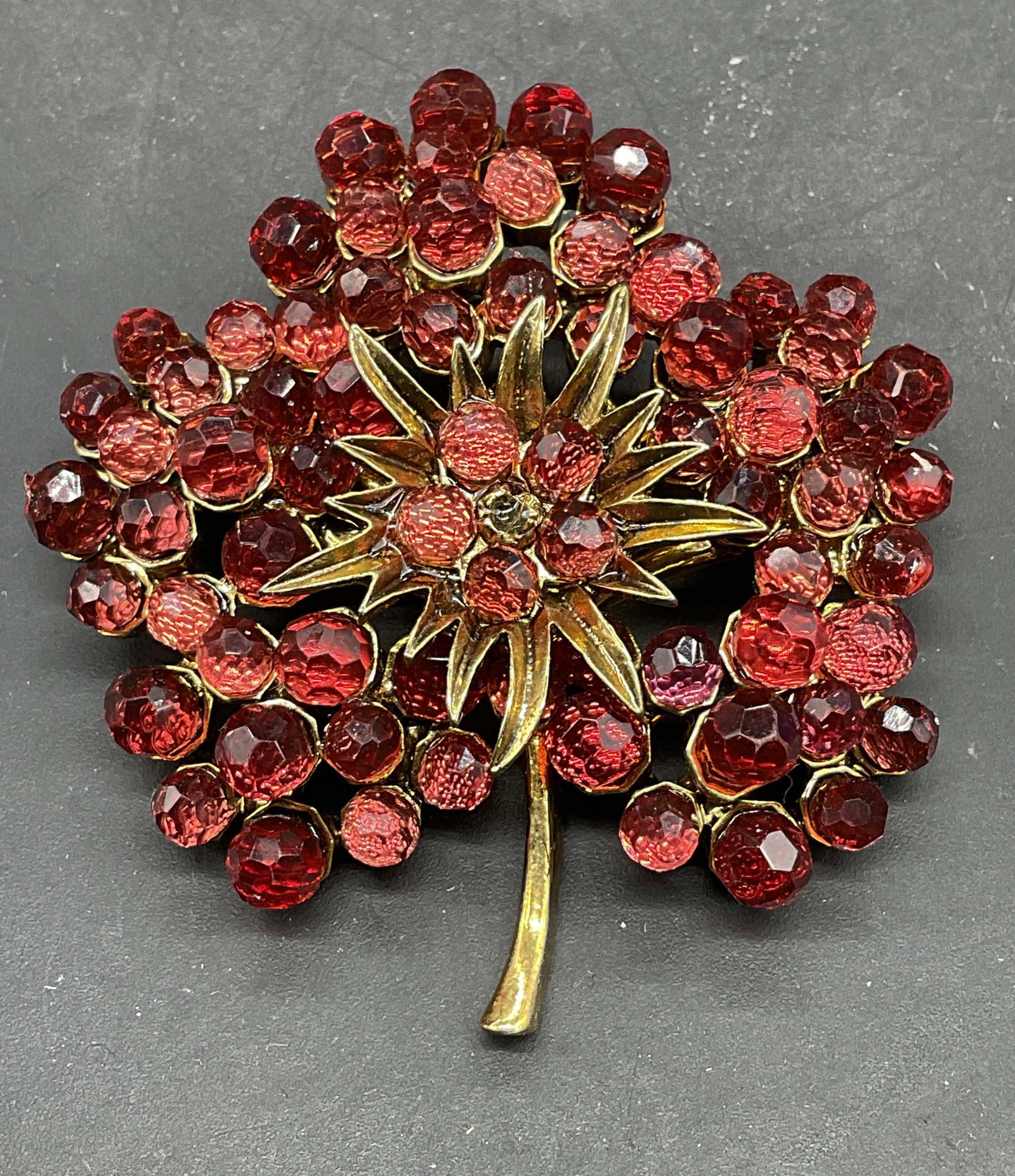 Vintage Monet Red Crystal Flower Brooch: Vintage Monet gold tone red Crystal flower brooch. Measures approx. 2.25 x 2 inches. Some scratching. One crystal needs replacement. Jewelry, estate jewelry, costume jewelry, cocktail jewelry, fashion