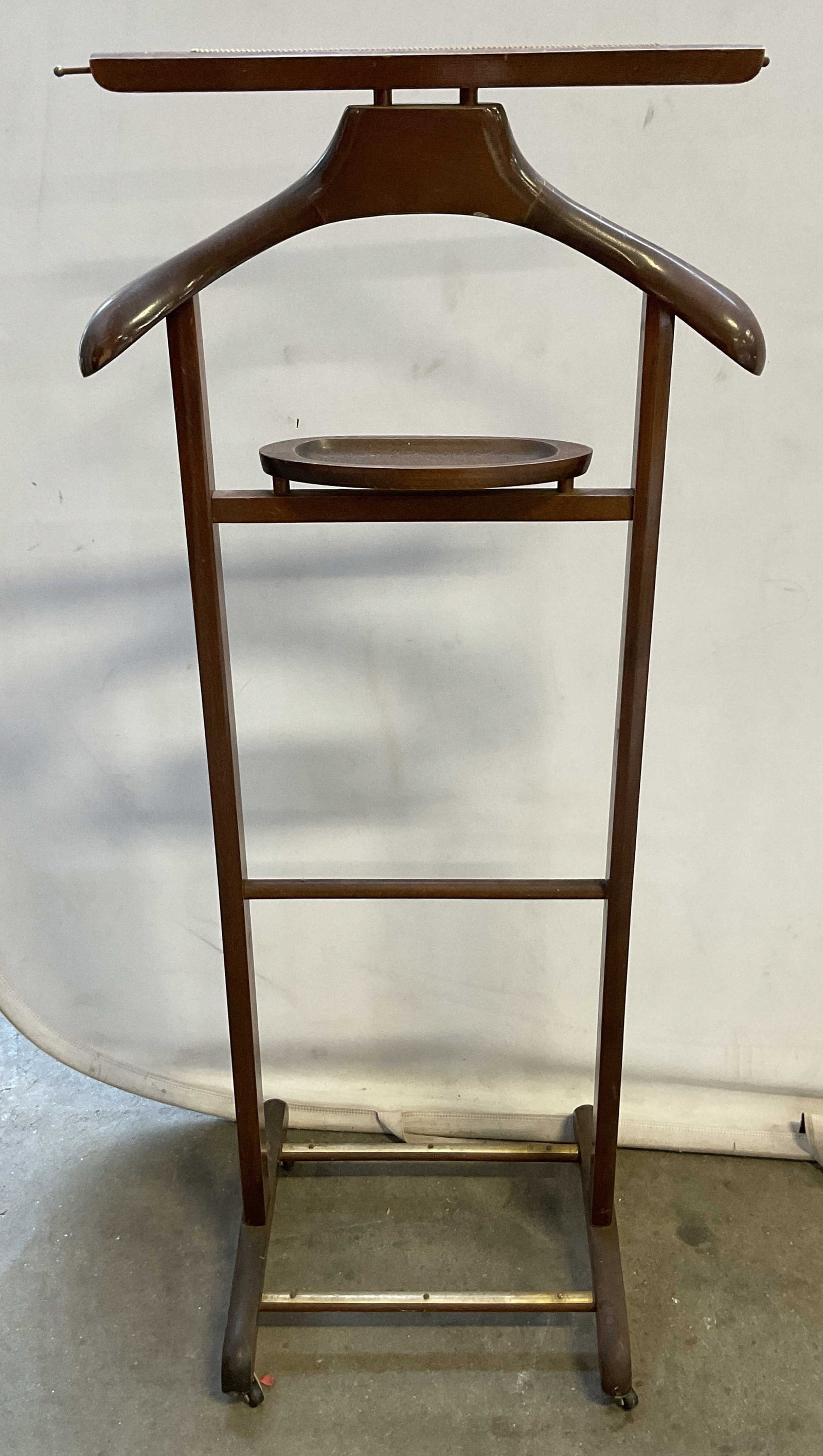 Vintage Wooden Valet Stand: Vintage wooden valet stand. Broad hanger at top. Horizontal bar hanger below. Oval shaped tray. Supported by four wheels. Measures approx 14 x 14 x 43 inches. Some scratching. Valet stand, furniture, 