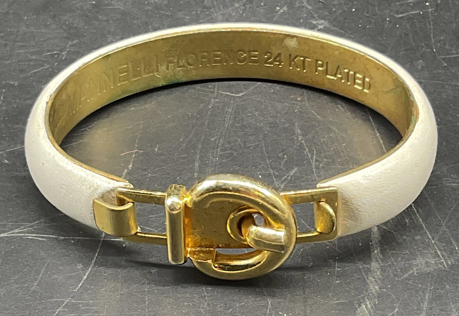 Mannelli Gold Plated Leather Buckle Bracelet Italy: Signed Mannelli 24k gold plated and white leather buckle motif bracelet. Made in Italy. Measures approx. 2.25 inches wide. Some scratching. Jewelry, estate jewelry, costume jewelry, cocktail jewelry, 