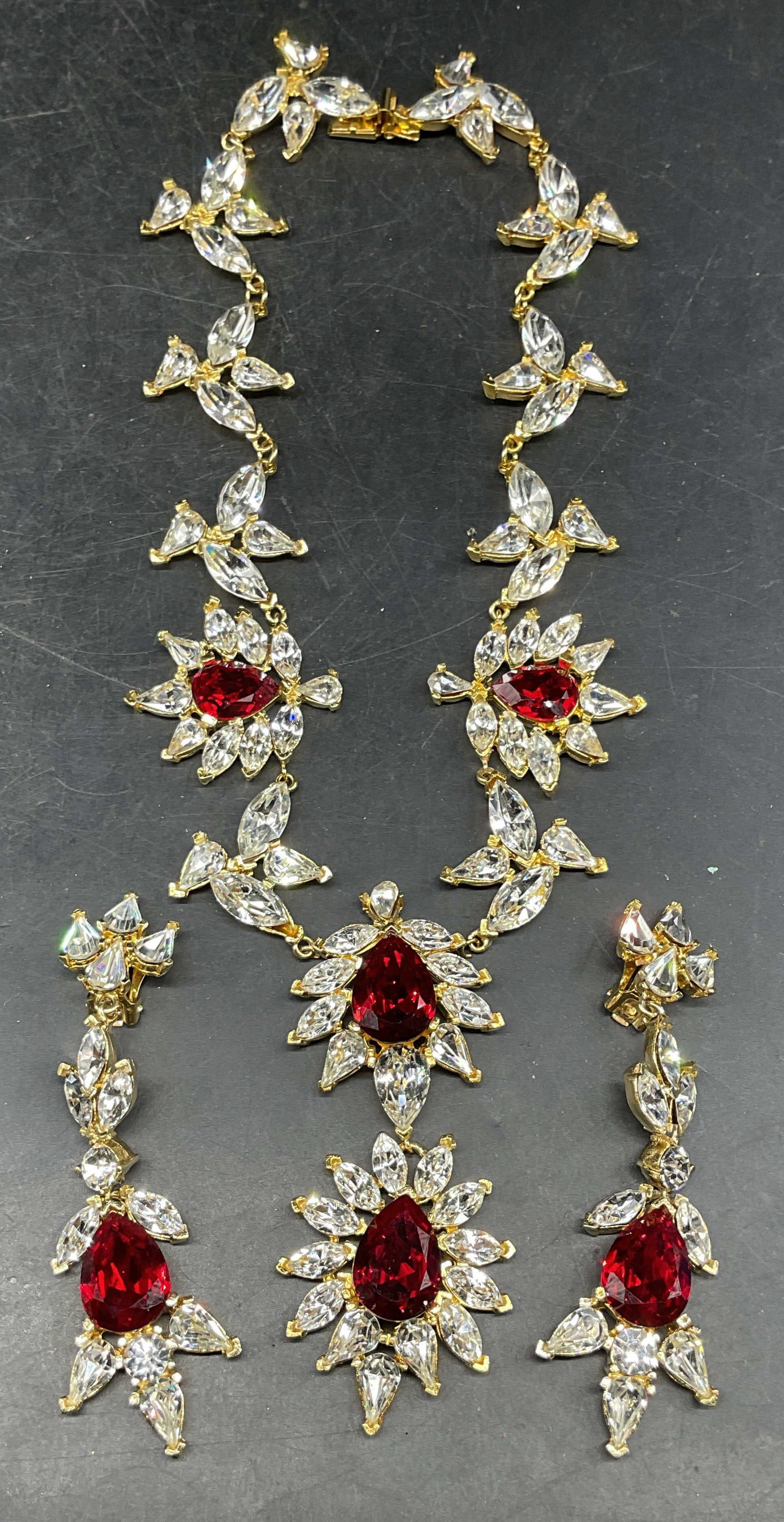 2 Todd Anthony Red Crystal Necklace & Earrings: Vintage signed Todd Anthony matching gold tone red and colorless crystal pendant necklace and chandelier earrings. Necklace drop length 6.5 inches. Earring measures approx. 3.5 inches long. Some scrat
