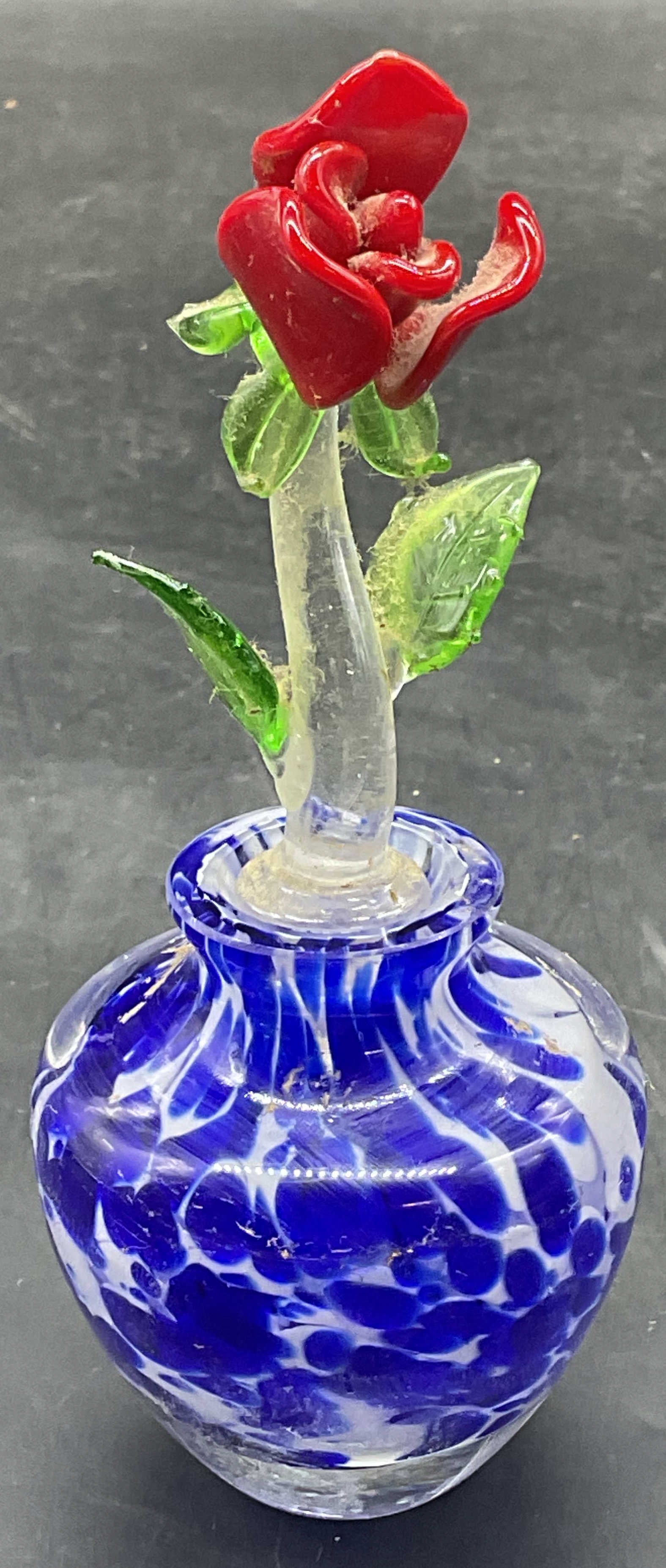 Blue Art Glass Flower Perfume Bottle: Hand blown art glass perfume bottle with flower motif stopper. Mottled blue. Measures approx. 2 x 2.25 inches. Stopper measures approx. 3,25 inches long. Some scratching, some chips to stopper. Art gl