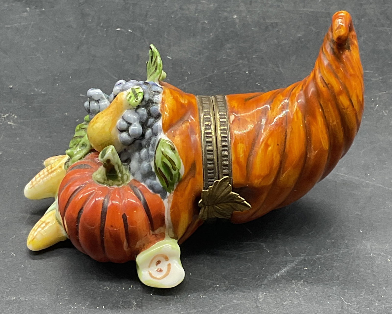 Studio USA Porcelain Cornucopia Trinket Box: Studio USA porcelain cornucopia fruit and vegetable trinket box. Hand painted. Measures approx. 2.75 x 1.75 x 1.75 inches. Some scratching, small chip. Studio USA trinket box, cornucopia trinket box, 