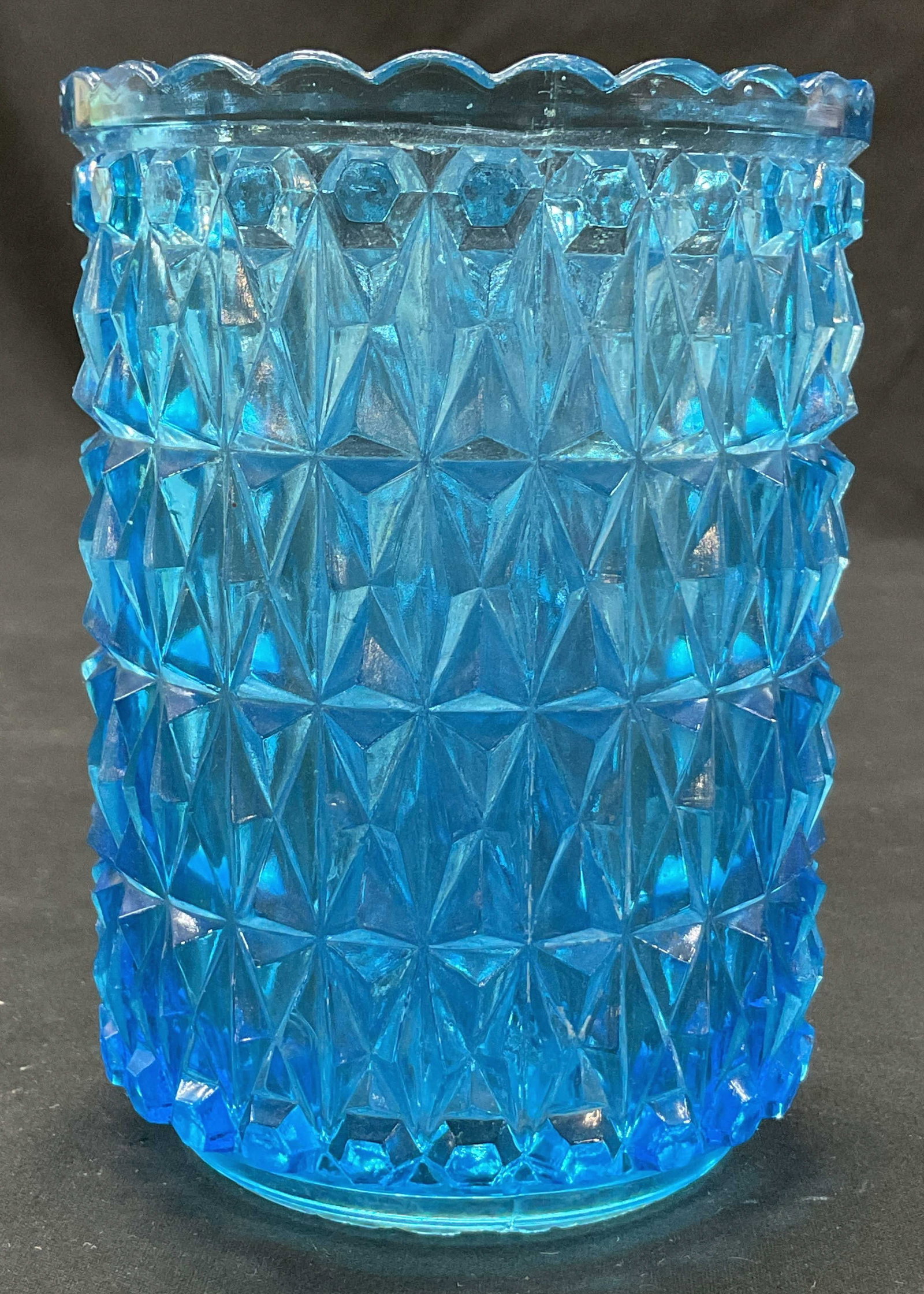 Vintage Blue Glass Geometric Vase: Vintage blue glass geometric vase. Tall cylinder shape. Scalloped edge. Raised geometric pattern. Textured surface. Bright blue color. Measures ht approx 5 inches diam approx 3.5 inches. Some scratchi