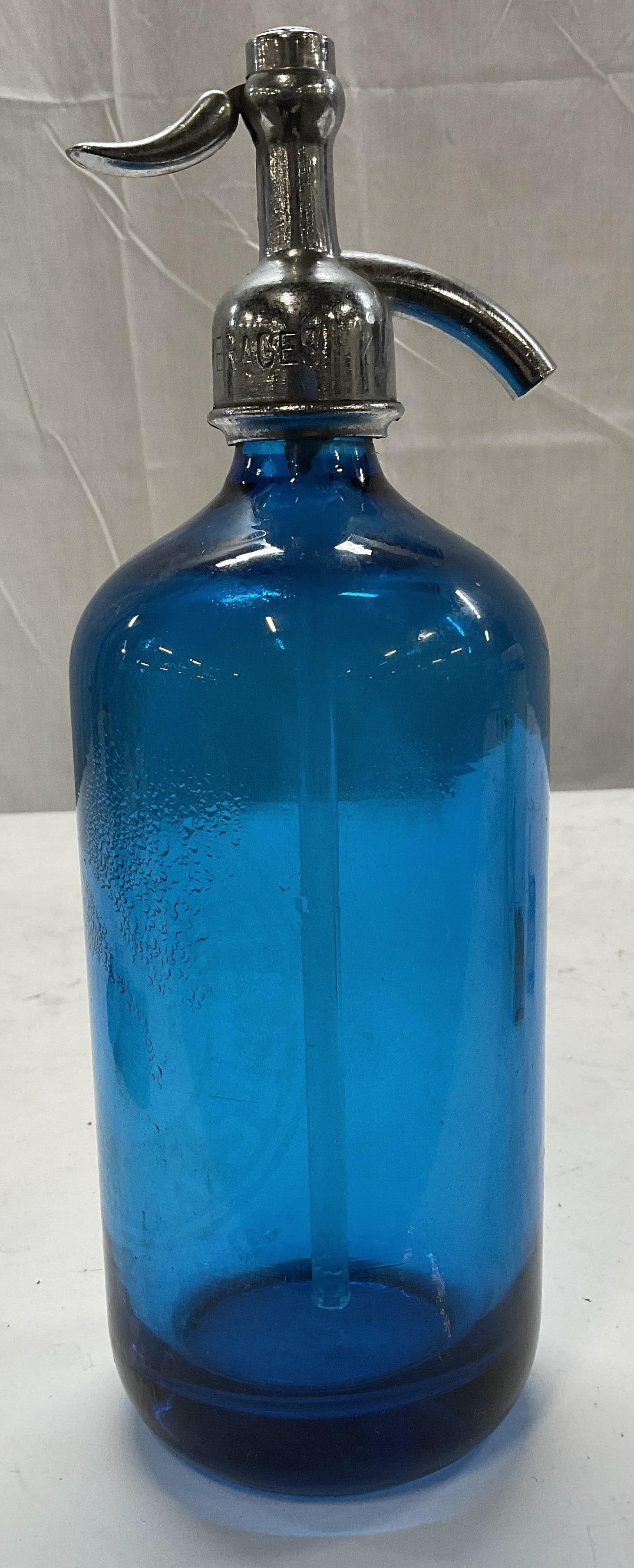 VTG Blue Art Glass Soda Siphon CZECHOSLOVAKIA: Vintage Blue Art Glass Soda Siphon. Silver-Toned Metal Spigot. Bottom Reads Bottle Made in Czechoslovakia. Front Reads Lakeland Beverages Morell Peekskill NY 26 FL Oz. Some Scratching and Aging.