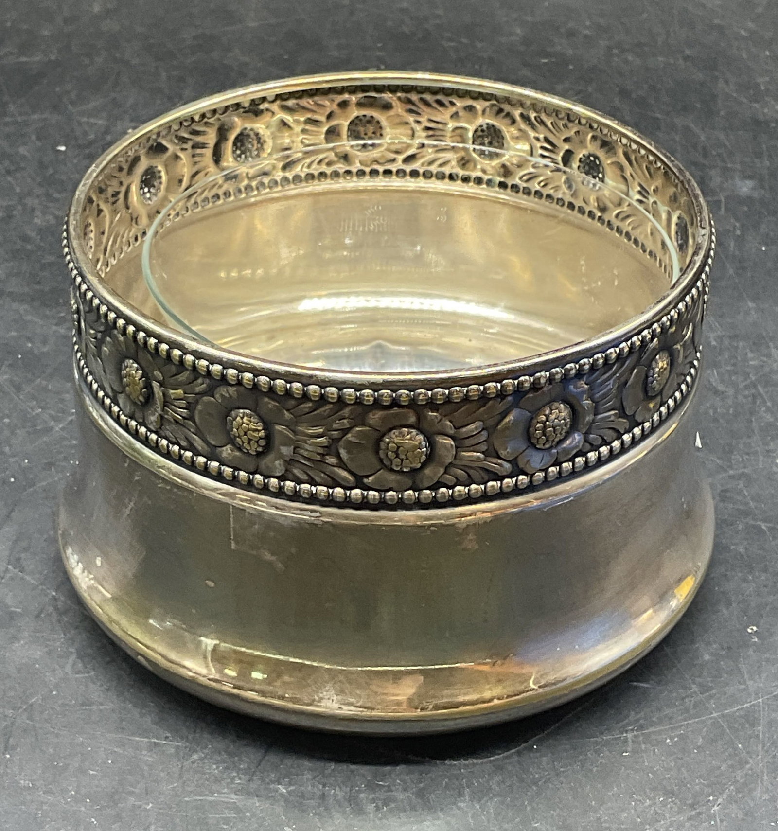 Vintage Silver Plated Floral Bowl & Glass Insert: Vintage silver plate bowl with repousse floral rim. Includes a clear glass insert. Silver plated bowl measures approx. 4.25 x 2.5 inches. Some scratching, patina, loss to plating. Silver plated bowl,