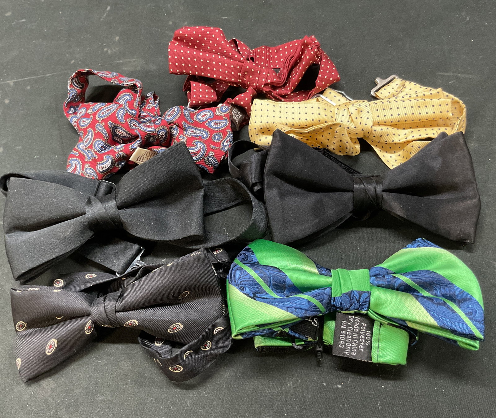 Lot 7 Assorted Pattern Silk Bow Ties: Lot of 7 assorted pattern silk bow ties. Brand includes John Henry and Steve Harvey. Varying colors ranging from black, yellow, red, and more. Various patterns include polka dots, paisley, and more.