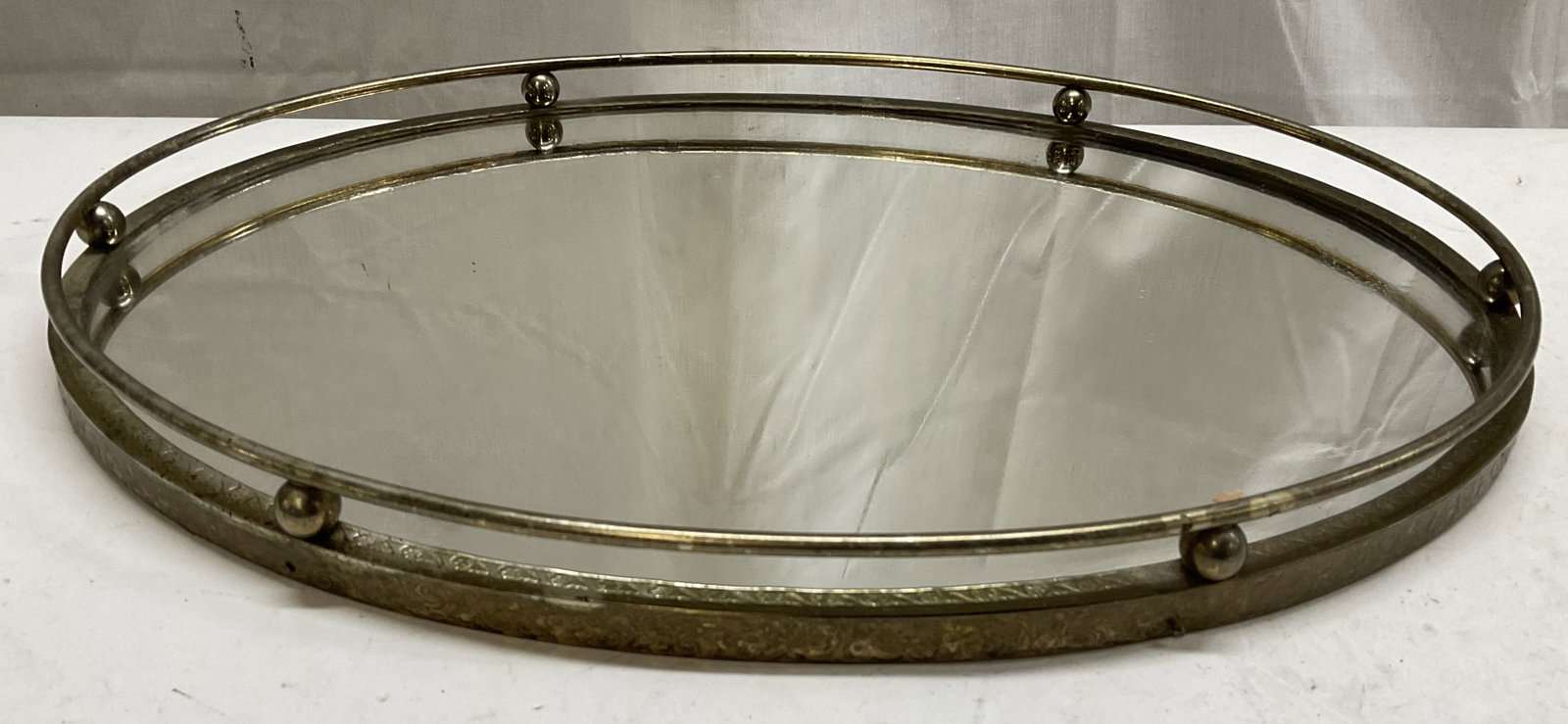 MCM Gold Toned Oval Mirrored Tray: Mid-Century Modern Gold Toned Metal Oval Mirrored Vanity Tray. Scratching and Tarnishing Present. Measures app 1in H x 13in Diam. Mid-Century Modern Tray, MCM, Gold Toned Metal, Oval Trays, Mirrored