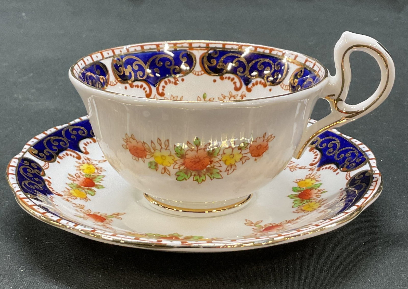 Set 2 Royal Standard Teacup & Saucer England: Set of 2 Royal Standard fine bone china teacup and saucer. Marked on underside, reads Royal Standard Fine Bone China England. Scalloped edge. Gilt scroll accents. Floral motifs in varying colors.