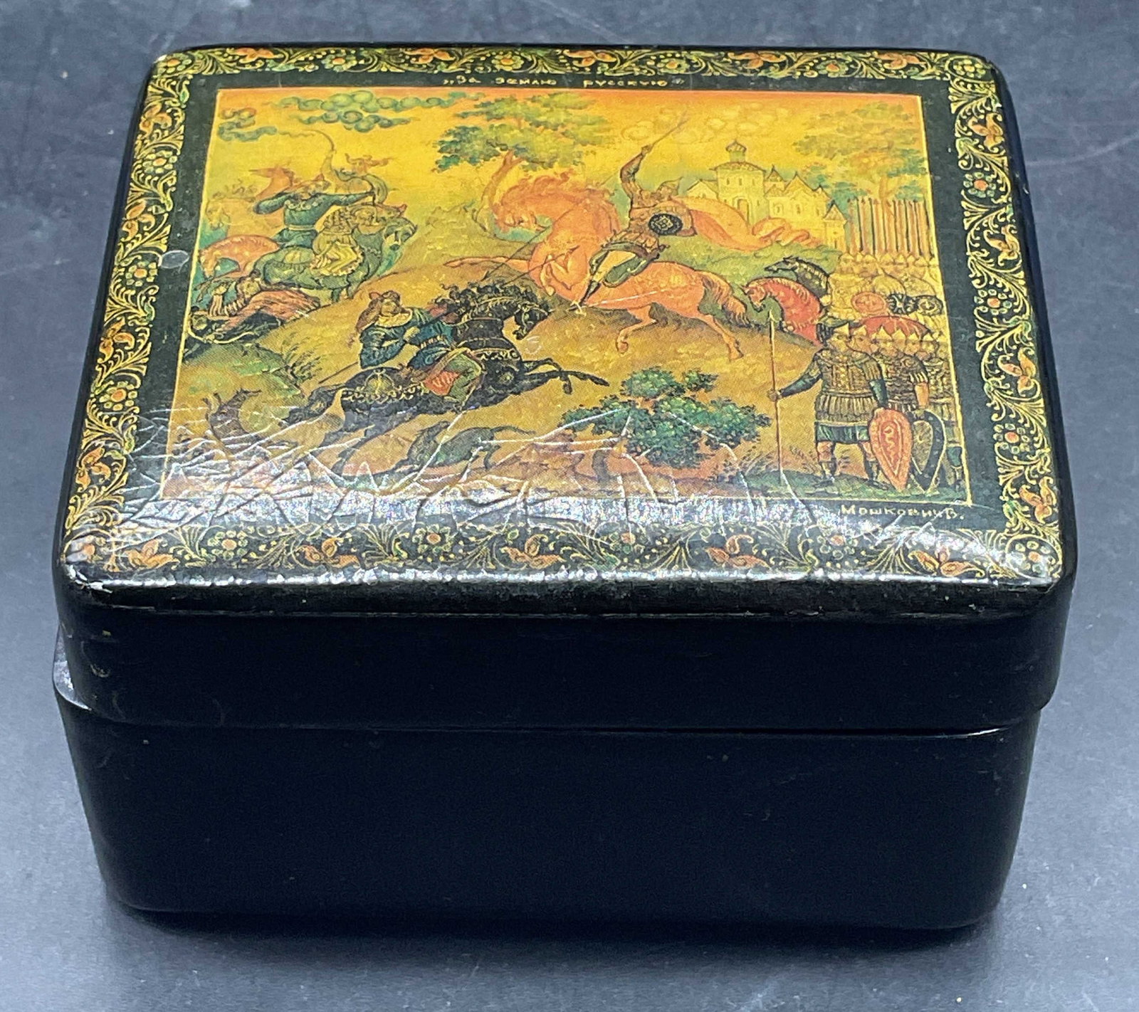 Vintage Russian Lacquered Wood Trinket Box: Vintage Russian style lacquered wood trinket box with printed battle scene on lid. Measures approx. 3 x 2.5 x 1.75 inches. Wear including scratching, crazing, lid hinge needs repair. Lacquered wood tr