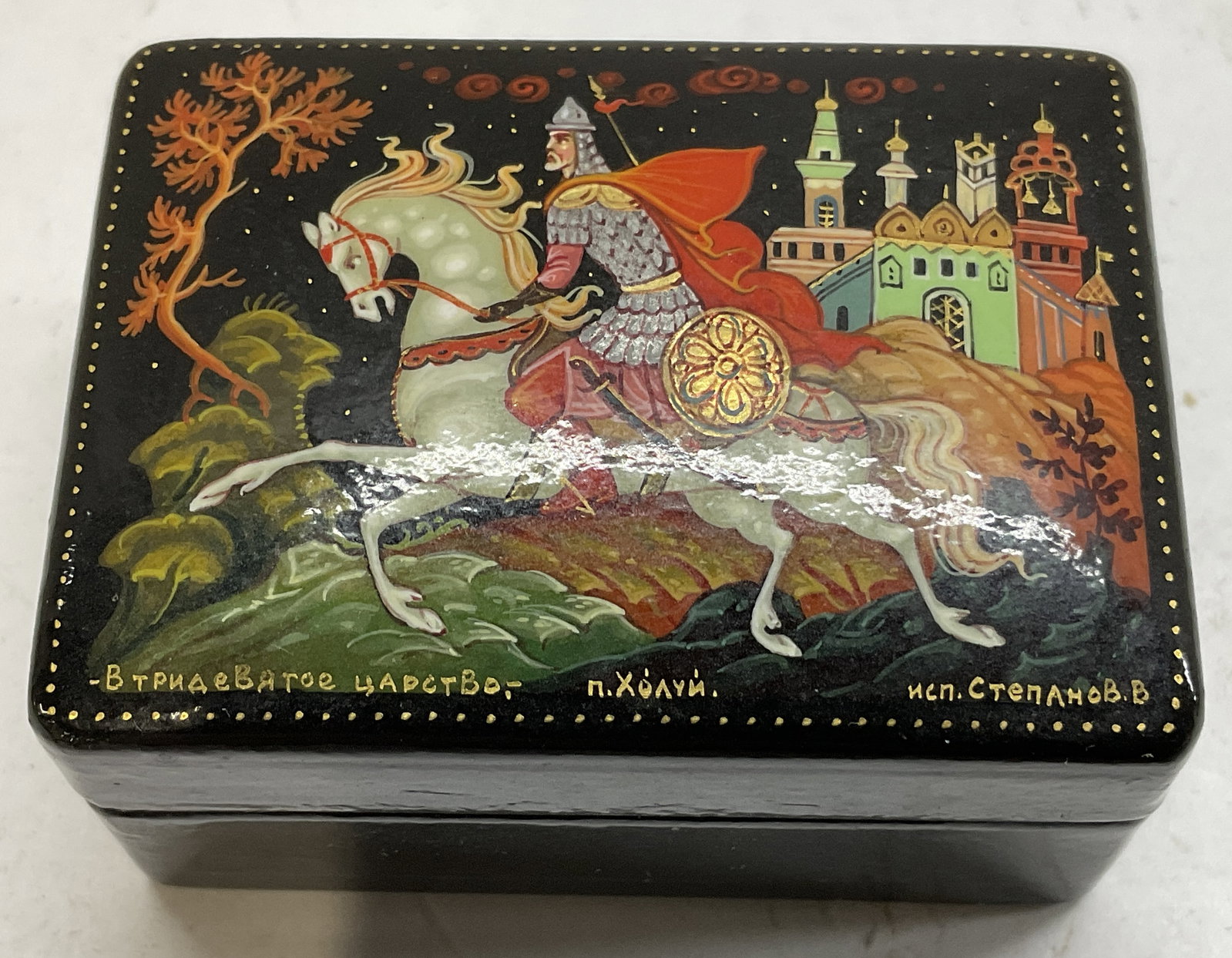 SGND 1in Pntd Fairy Tail Theme Russian Trinket Box: Signed Painted Fairy Tail Theme Russian Black Lacquer Trinket Box. Signed by the Artist in Russian. Bottom Reads Made in USSR. Depicts a Knight on Horseback with a Castle in the Background. Silver-Ton