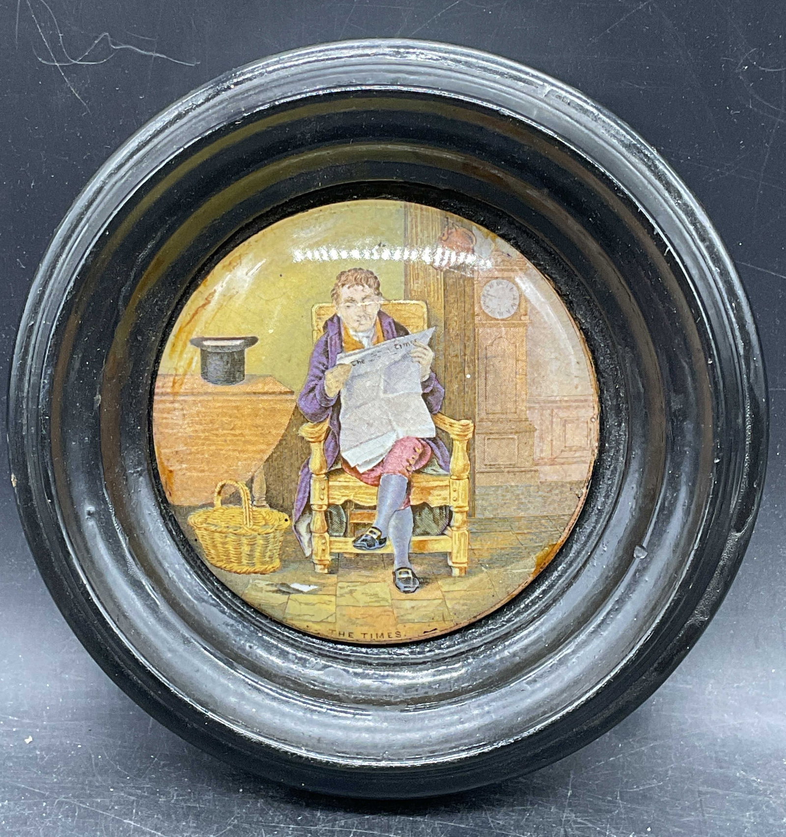 Antique Prattware The Times Pottery Lid: Antique Victorian Prattware pottery lid. Transferware print scene. The Times. Man reading newspaper. Black wood frame. Not examined out of frame. Frame measures approx. 6.75 inches wide. Wear includin