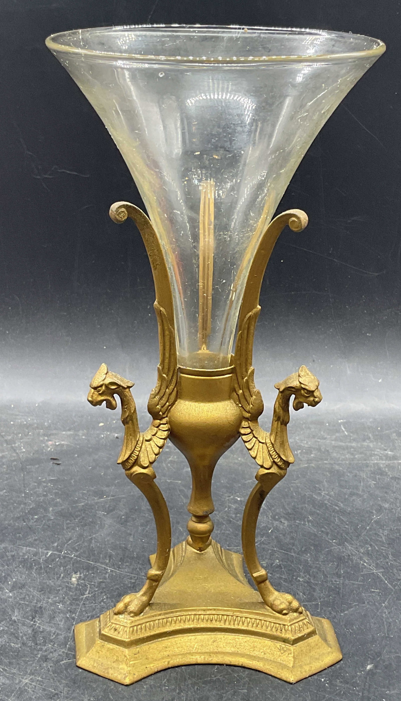 Antique Gilt Metal & Glass Cornet Vase: Antique cornet vase. Gilt metal stand with winged chimera tripartite base. Fluted glass vase insert. Measures approx. 4.75 x 9.5 inches. Numbered 179 on base. Wear including scratching and patina. Ant