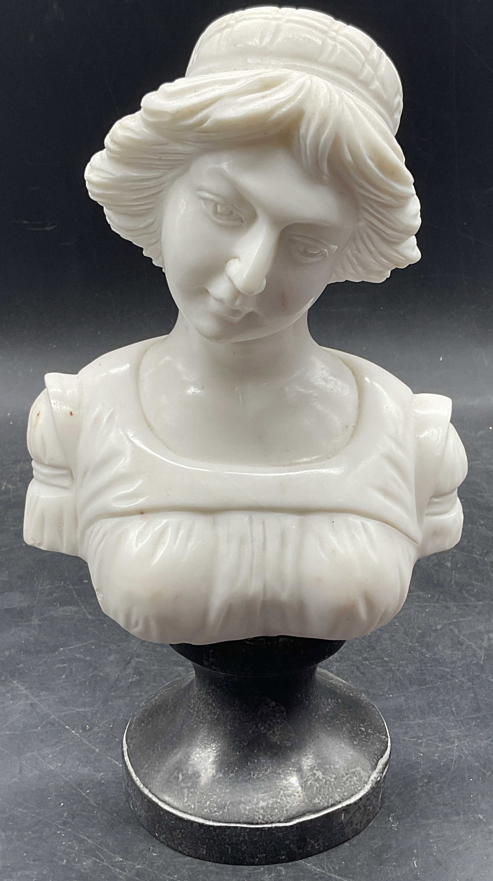 Antique Carved Marble Bust Of A Young Woman: Antique hand carved white marble bust of a young woman on black marble base. Measures approx. 5.5 x 4 x 10 inches. Some scratching and small chips. Piece has significant weight. Marble bust, bust of