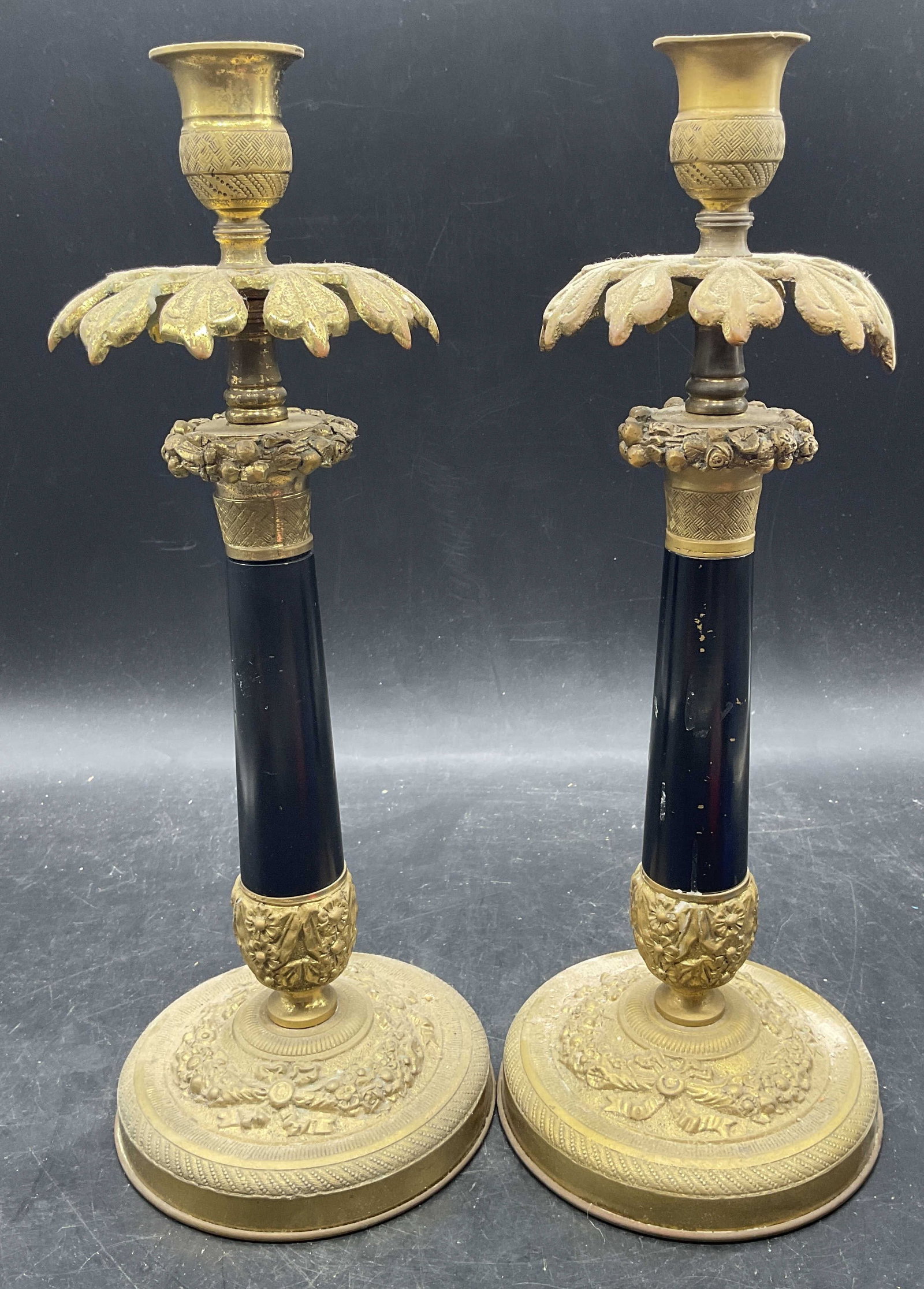 Pair Vtg Brass Enameled Ornate Candle Holders: Pair of vintage ornate brass candle holder with black enameled columns. Raised scroll design. Fluted capital sconces. Measures approx. 4.5 x 12.5 inches. Wear including patina, loss to enamel,