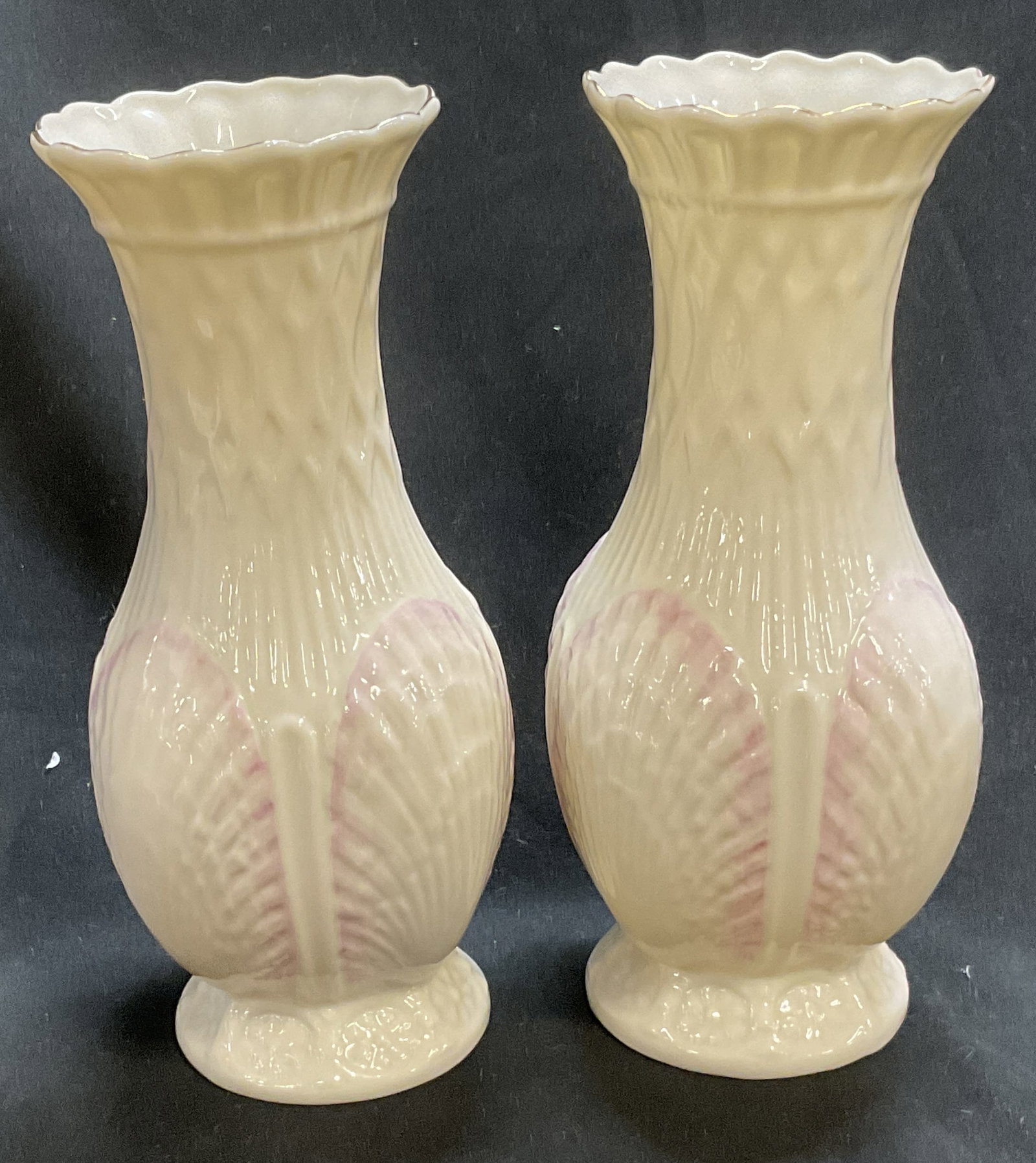 Lt2 Belleek Pink Scallop Shell Porc Vases IRELAND: 2 Belleek Porcelain Vases. Ireland. Cream Colored with Pink Scallop Shell Design. Condition Consistent with Exposure. Measures app 8in H x 3in Diam. Beleek, Porcelain Vases, Scallop Shell Design, Scal