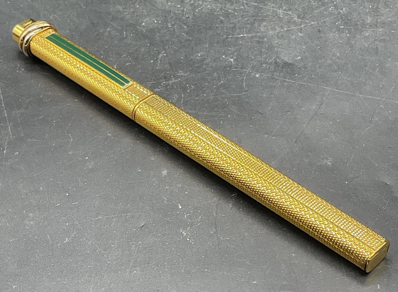 Vintage Cartier Gold Plated Ballpoint Pen France: Vintage Cartier ballpoint pen. Gold plated case with textured surface and green enamel stripe decoration. Trinity band motif on cap. Made in France. Numbed 218533. Measures approx. 5.25 inches long. N
