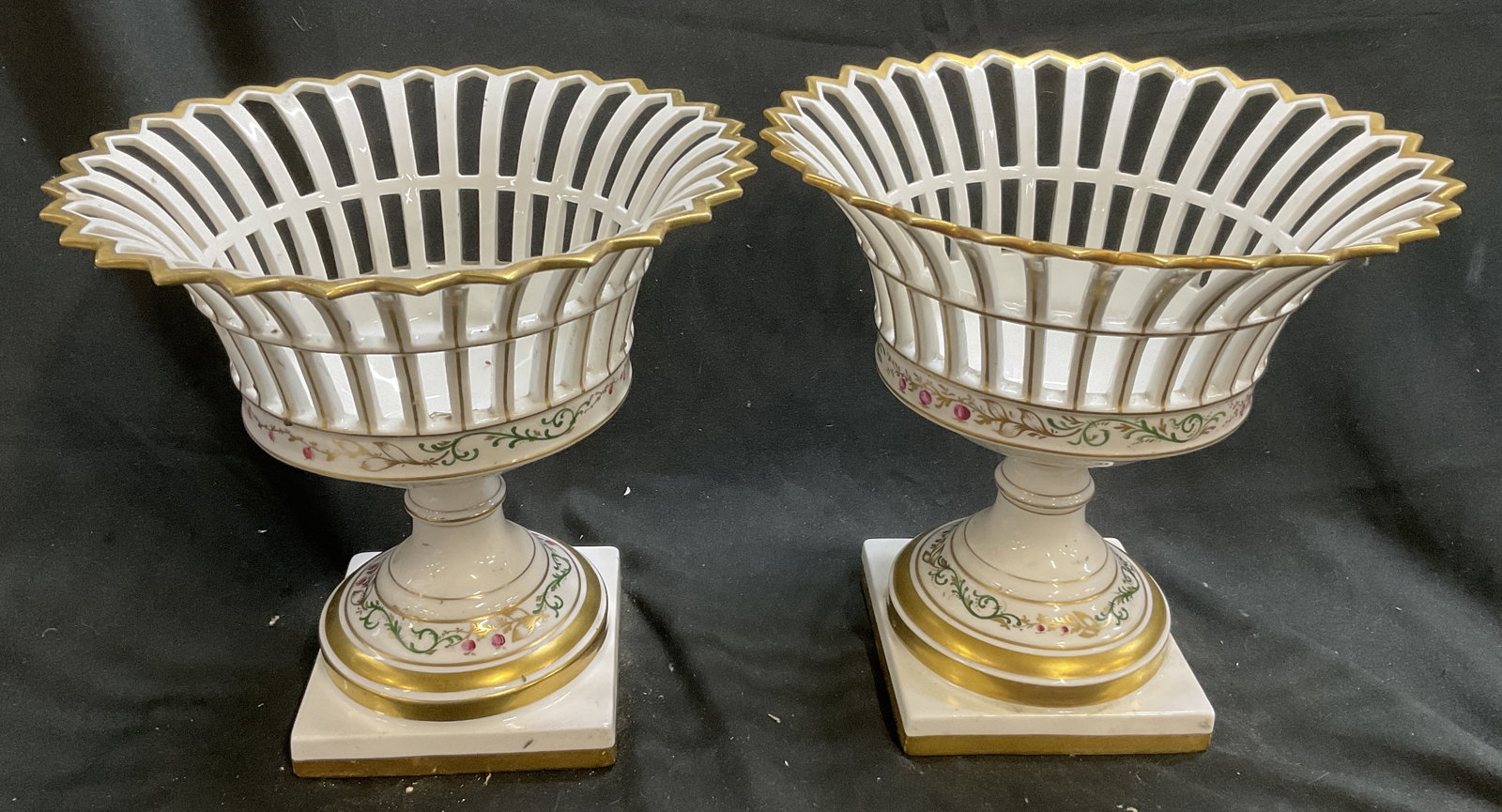 Pair Vista Alegre Porc Basket Pedestals PORTUGAL: Pair of Vista Alegre Porcelain Basket Pedestals. Hand-Painted Floral Motifs. Gilt Accents. Made in Portugal. Condition Consistent with Exposure. Measures app 9.5in H x 5in Base. Vista Alegre,