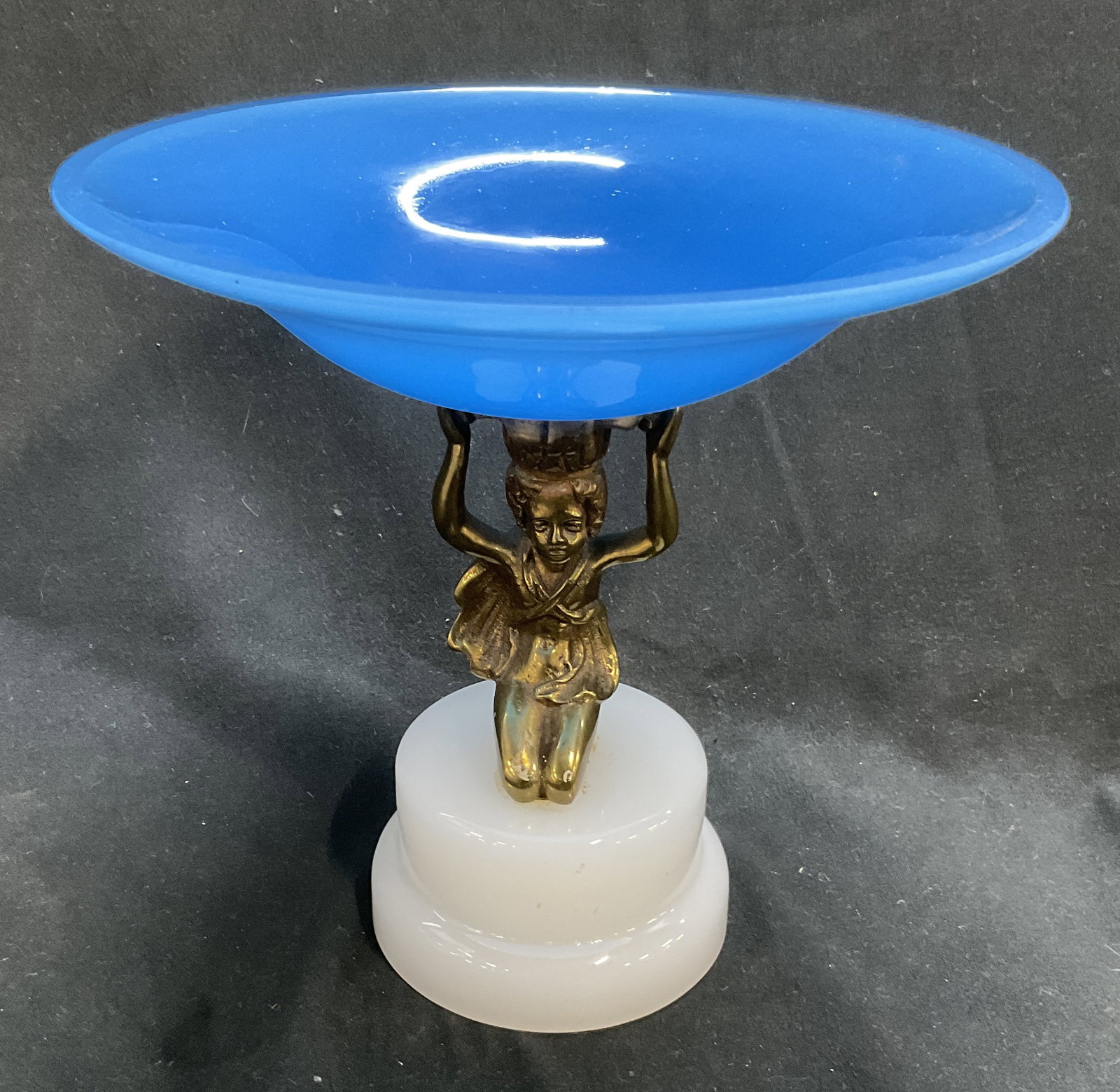 Art Deco Sty Brass Cherub Art Glass Compote Dish: Art Deco Style Brass Cherub and Art Glass Compote Dish. Blue Opaque Art Glass Bowl with White Opaque Art Glass Base. Condition Consistent with Exposure. Measures app 6.5in H x 3in Base. Art Deco
