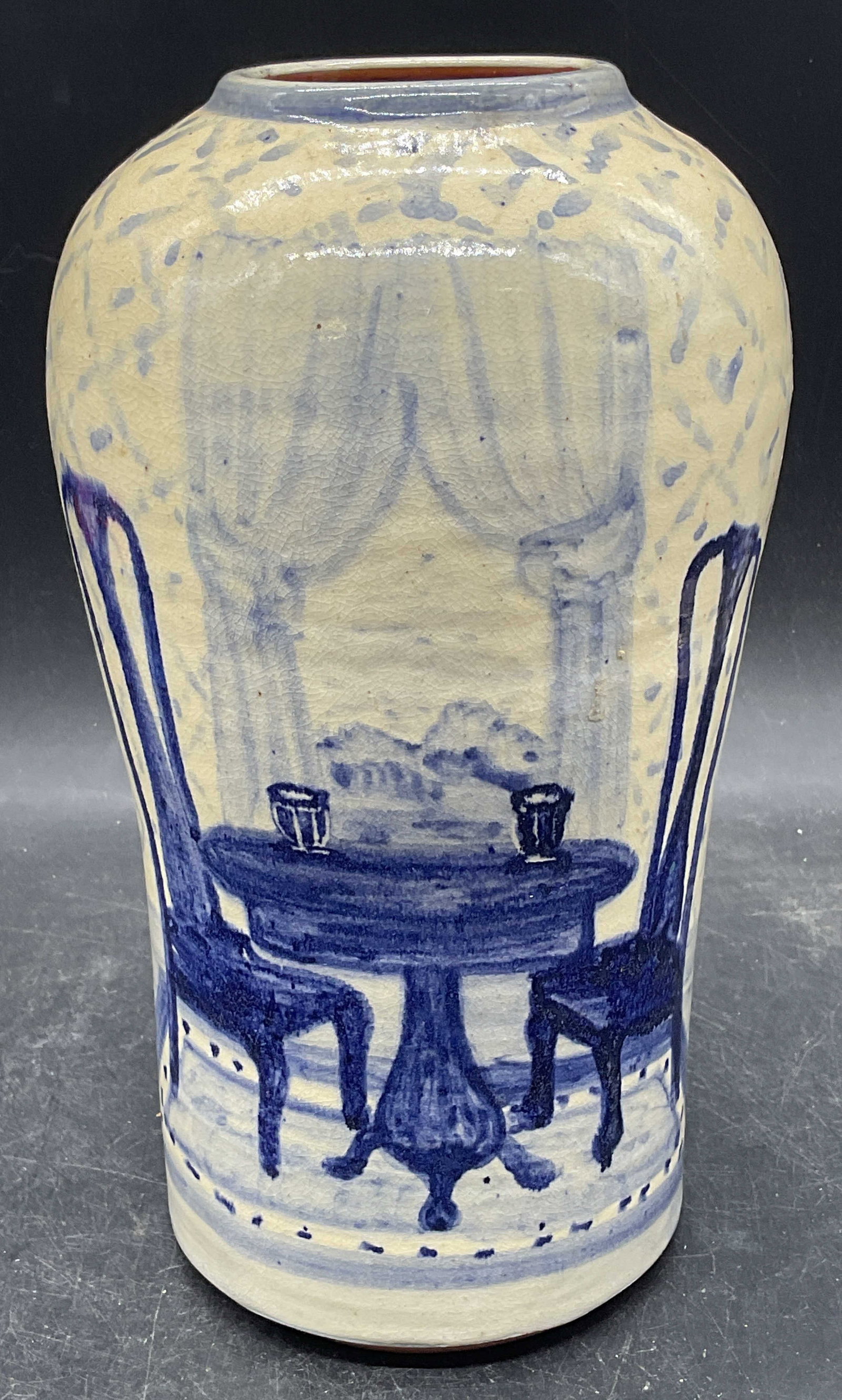 Signed Vintage Handmade Pottery Still Life Vase: Vintage 1987 signed handmade pottery vase. Hand painted with still life chairs and table scene in blue and white. Signed illegibly, possibly Lauren. Measures approx. 5 x 9 inches. Some scratching and 