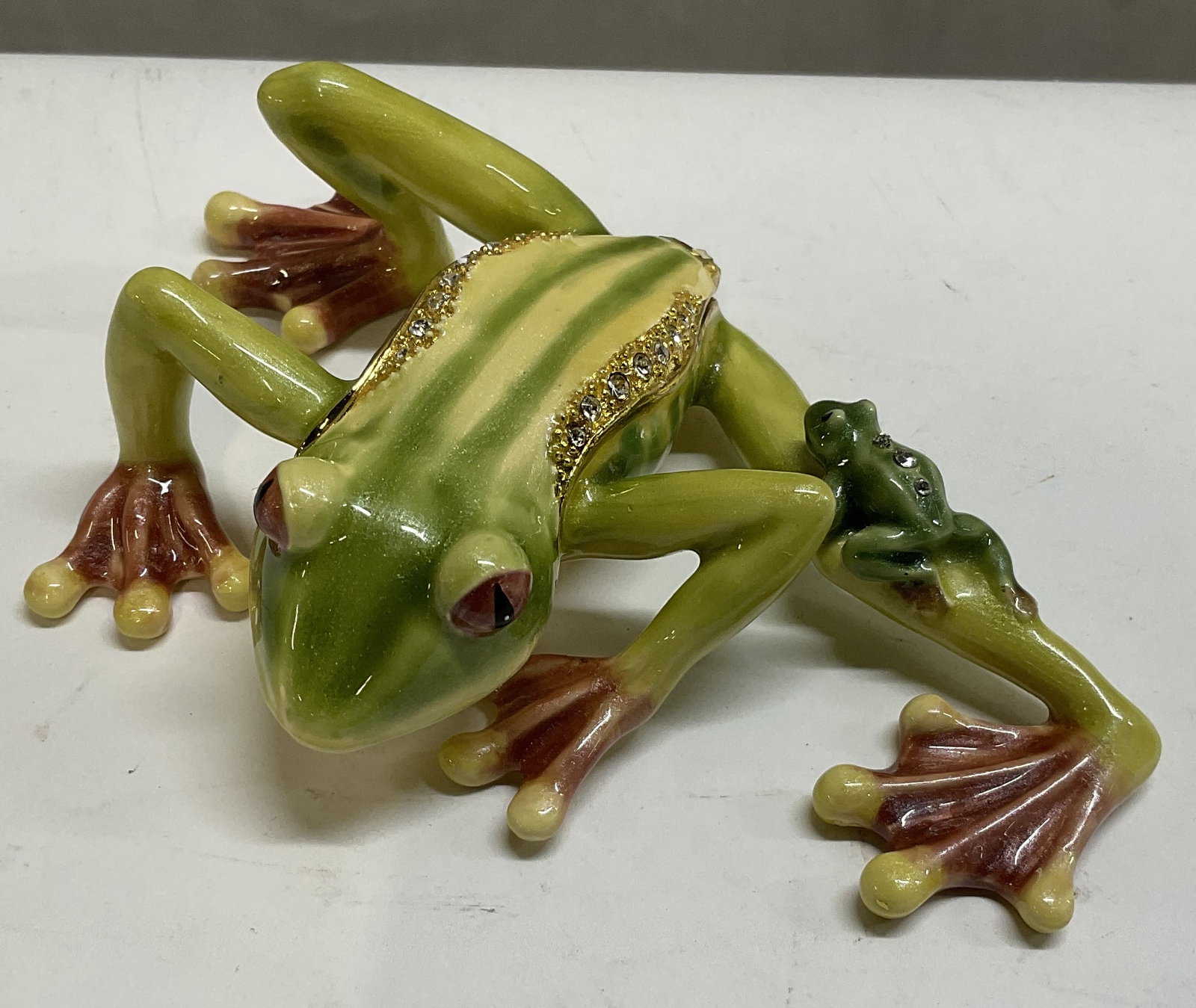 Magnetic Tree Frog with Baby Trinket Box: Magnetic Tree Frog with Baby Trinket Box. Colorful Enamel Over Gold Toned Metal. Embedded Crystals. Condition Consistent with Exposure. Measures app 1.25in H x 4.25in L. Magnetic Trinket Box, Tree