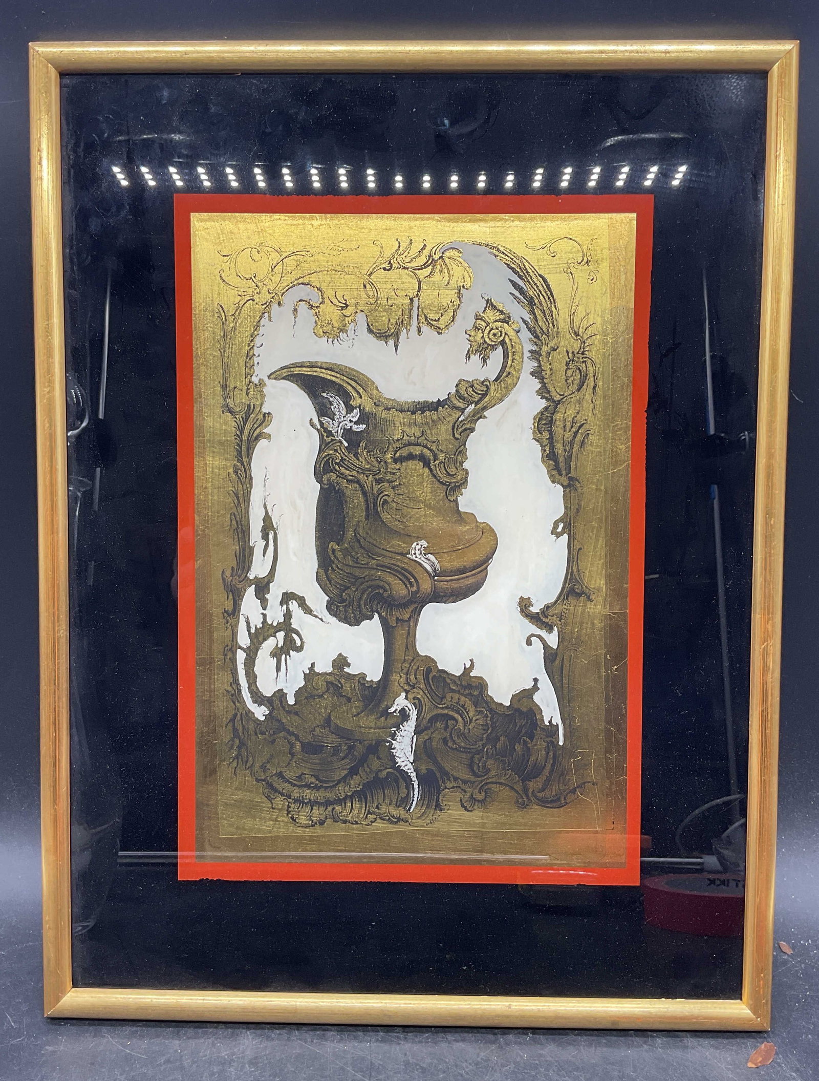 Framed Ornate Gold Leaf Reverse Painting: Framed reverse painting on glass with gold leaf. Ornate pitcher with seahorse. Gilt wood frame. Not examined out of frame. Frame measures approx. 16.75 x 12.75 inches. Some wear consistent with