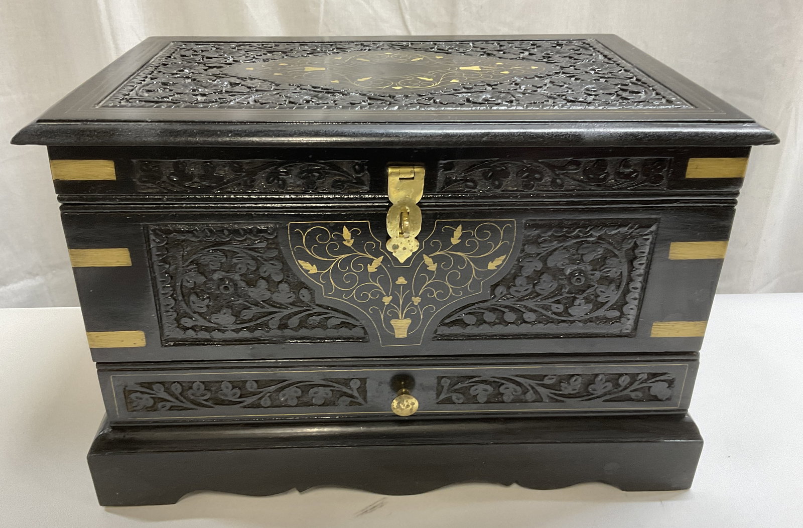 ANTQ Anglo-Indian Carved Ebony Wood Table Cabinet: Antique Anglo-Indian Carved Ebony Wood Table Cabinet. Brass Clasp and Gilt Floral Design and Accents. Comes with Locking Mechanism. Aging to Metal. Measures app 12in H x 18in L. Antique Furniture,