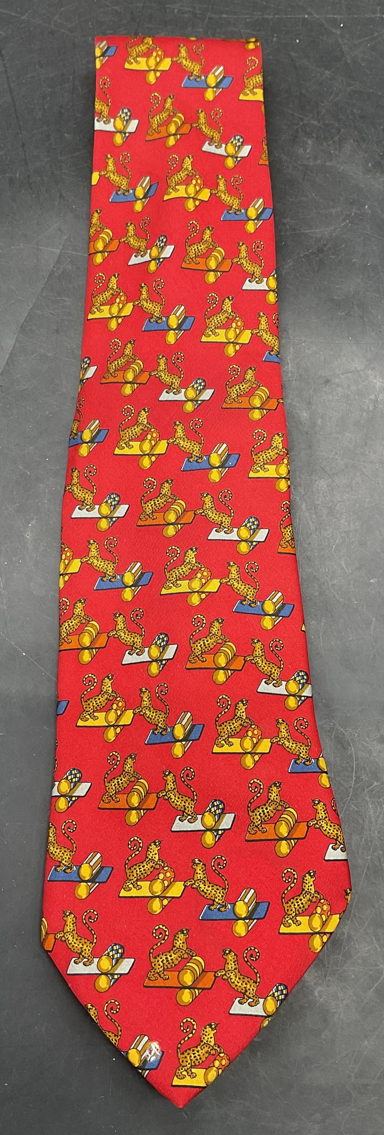 Salvatore FERRAGAMO Red Silk Cheetah Tie Italy: Salvatore FERRAGAMO red silk tie with whimsical cheetah print. Made in Italy. Measures approx. 58 inches. Some small holes on reverse. Salvatore FERRAGAMO tie, silk tie, design tie, cheetah tie, red