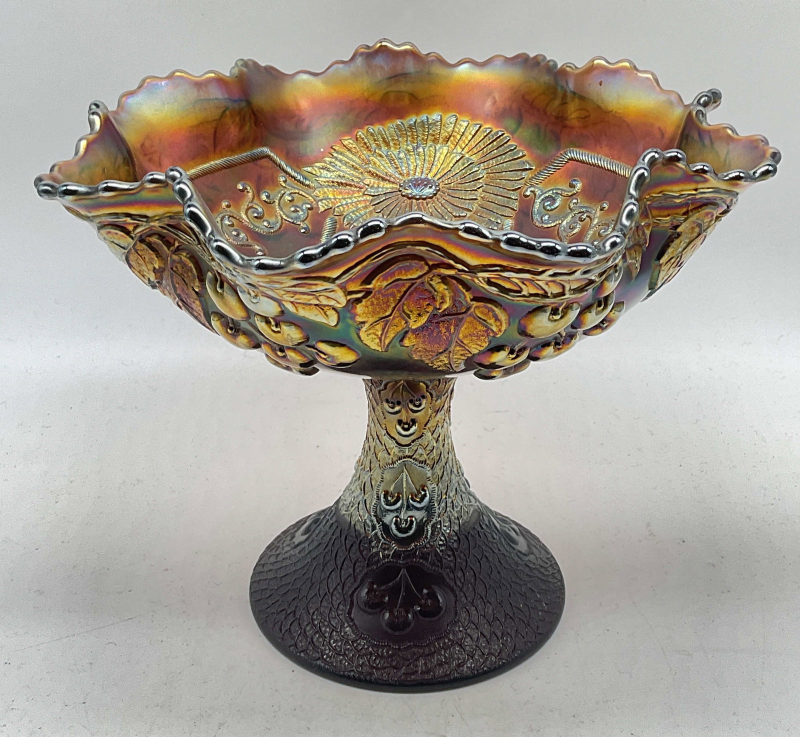 Vtg Amethyst Carnival Glass Cherry Footed Bowl: Vintage amethyst carnival glass compote/footed bowl. Handkerchief rim. Raised cherry, floral, and scroll patterns. Measures approx. 9.5 x 7.75 inches. Some scratching. Amethyst glass bowl, carnival