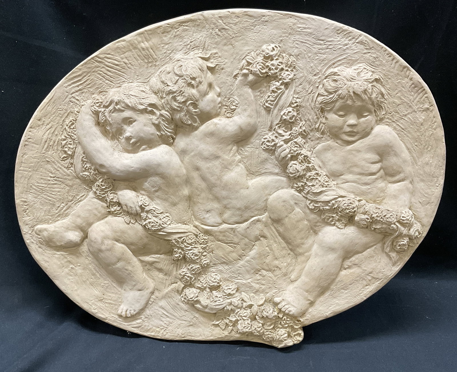 VTG Hen-Feathers High-Relief Putti&Roses Plaque: Vintage Hen-Feathers High-Relief Putti With Rose Garland Oval Wall Plaque. Made of Resin. Condition Consistent with Exposure. Measures app 14.75in H x 18.5in Diam. Vintage Wall Decor, Hen-Feathers,