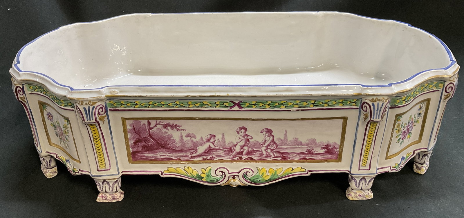 ANTQ Sceaux Faience Footed Jardiniere FRANCE 16in: Antique Stamped Sceaux Faience Footed Jardiniere. France. Painted Cherub and Floral Motifs. Condition Consistent With Exposure. Measures app 4.5in H x 16.5in Diam. Antique Planters, Sceaux, Faience,