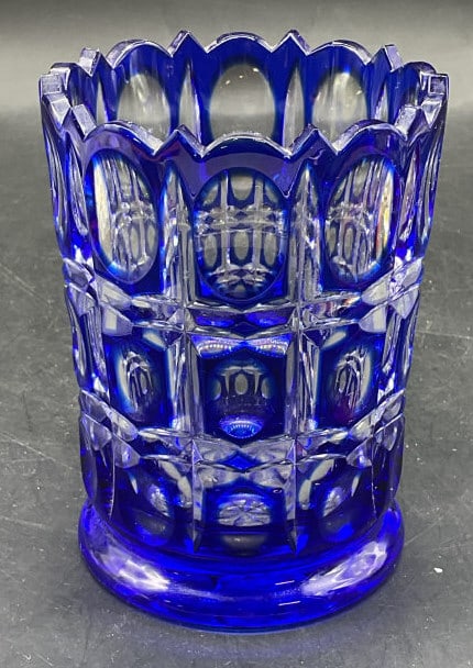 Signed Cobalt to Clear Cut Crystal Vase: Signed bohemian style cobalt blue to clear cut crystal vase. Scalloped rim with oval paneled design. Signed illegibly on underside. Measures approx. 3.75 x 5 inches. Some scratching. Cut crystal
