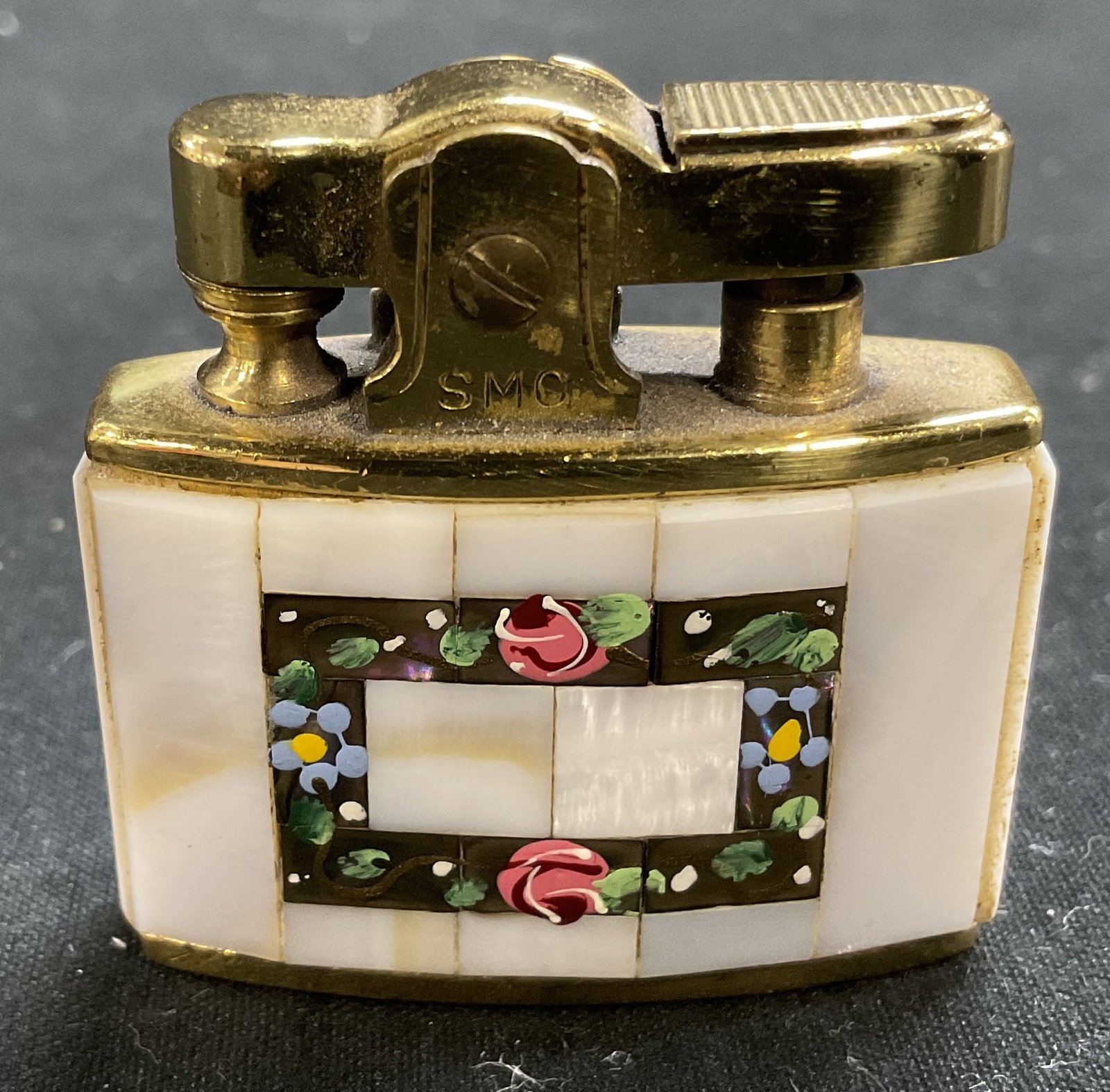 VTG SMC Supreme Pearl Auto Precision Lighter JPN: Vintage SMC Supreme Mother-Of-Pearl Design Automatic Precision Lighter. Gold Toned Metal. Painted Florals. Japan. Some Scratching. Measures app 1.5in H x 0.25in W. Vintage Lighters, SMC Supreme,