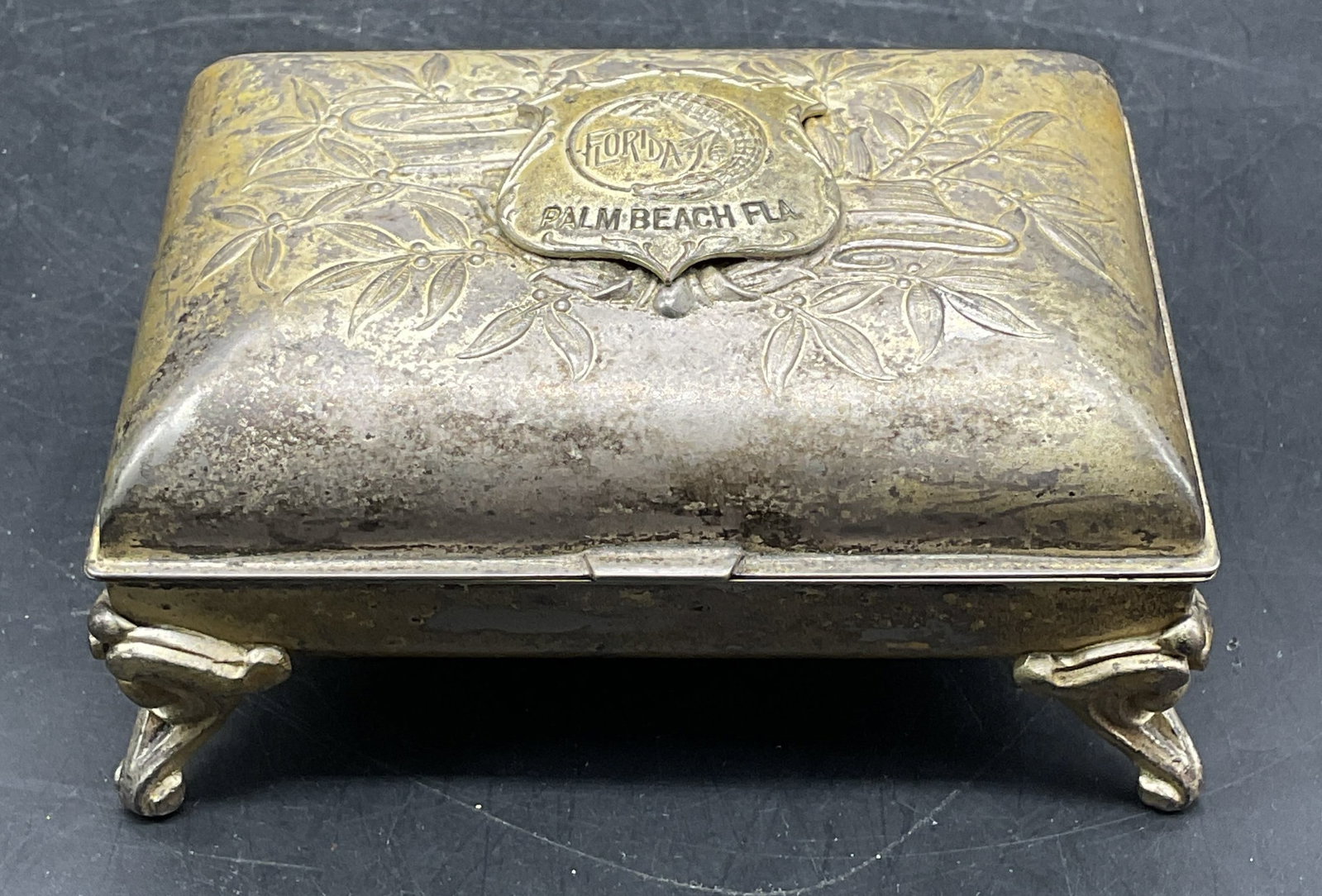 Antique K & Co Silver Tn Palm Beach Jewelry Box: Antique K & Co silver and gold tone cast metal jewelry box. Embossed botanical and alligator motif. Palm Beach, Florida souvenir. Lined interior. Measures approx. 4 x 2.75 x 2 inches. Wear including