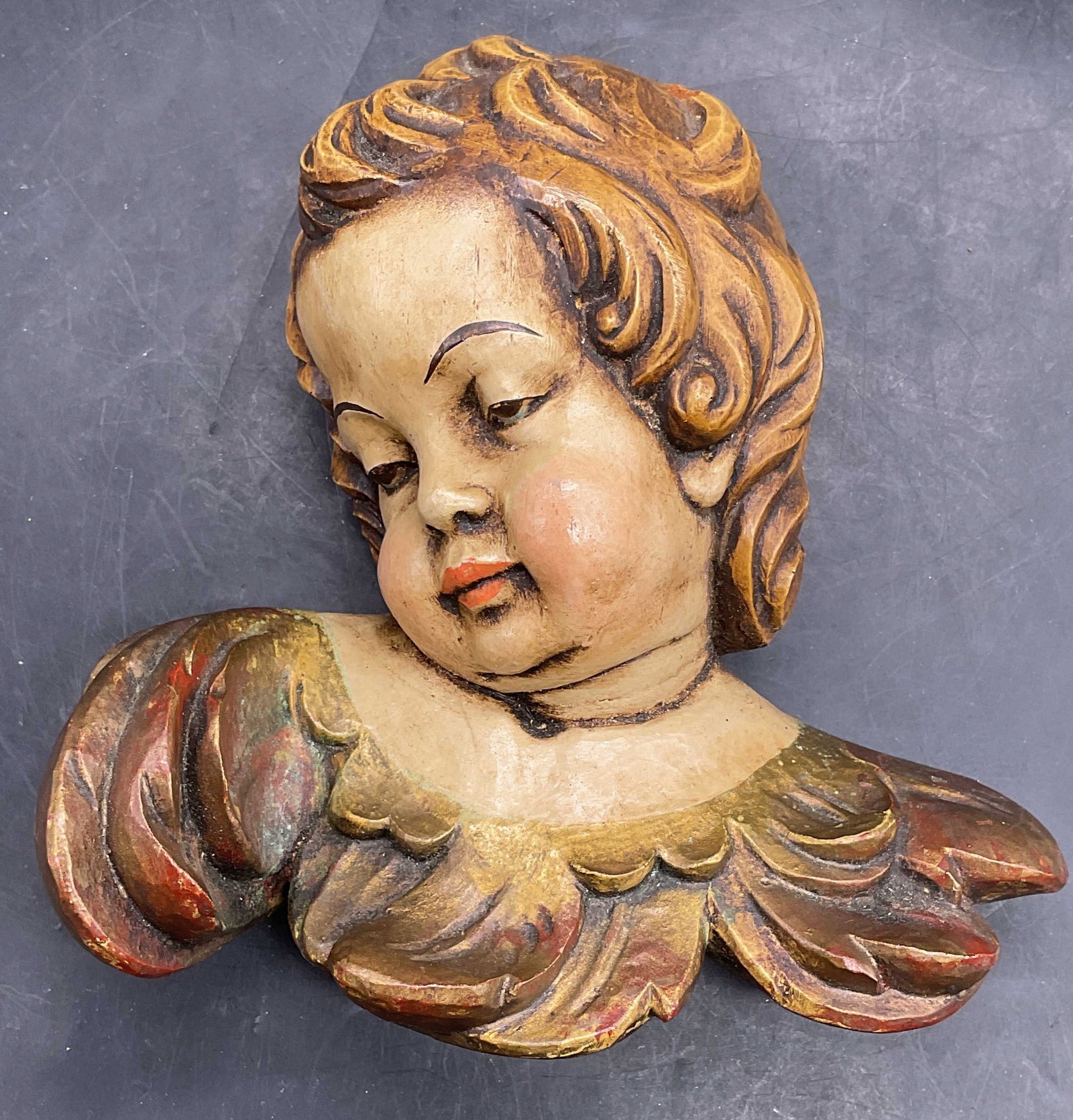 Vintage Gilt Painted Wood Cherub Head Plaque: Vintage carved wood cherub head plaque with hand painted and gilt decoration. Measures approx. 6.5 x 6.5 x 3 inches. Some scratching and loss to pigments. Wood cherub, cherub plaque, collectibles, hom