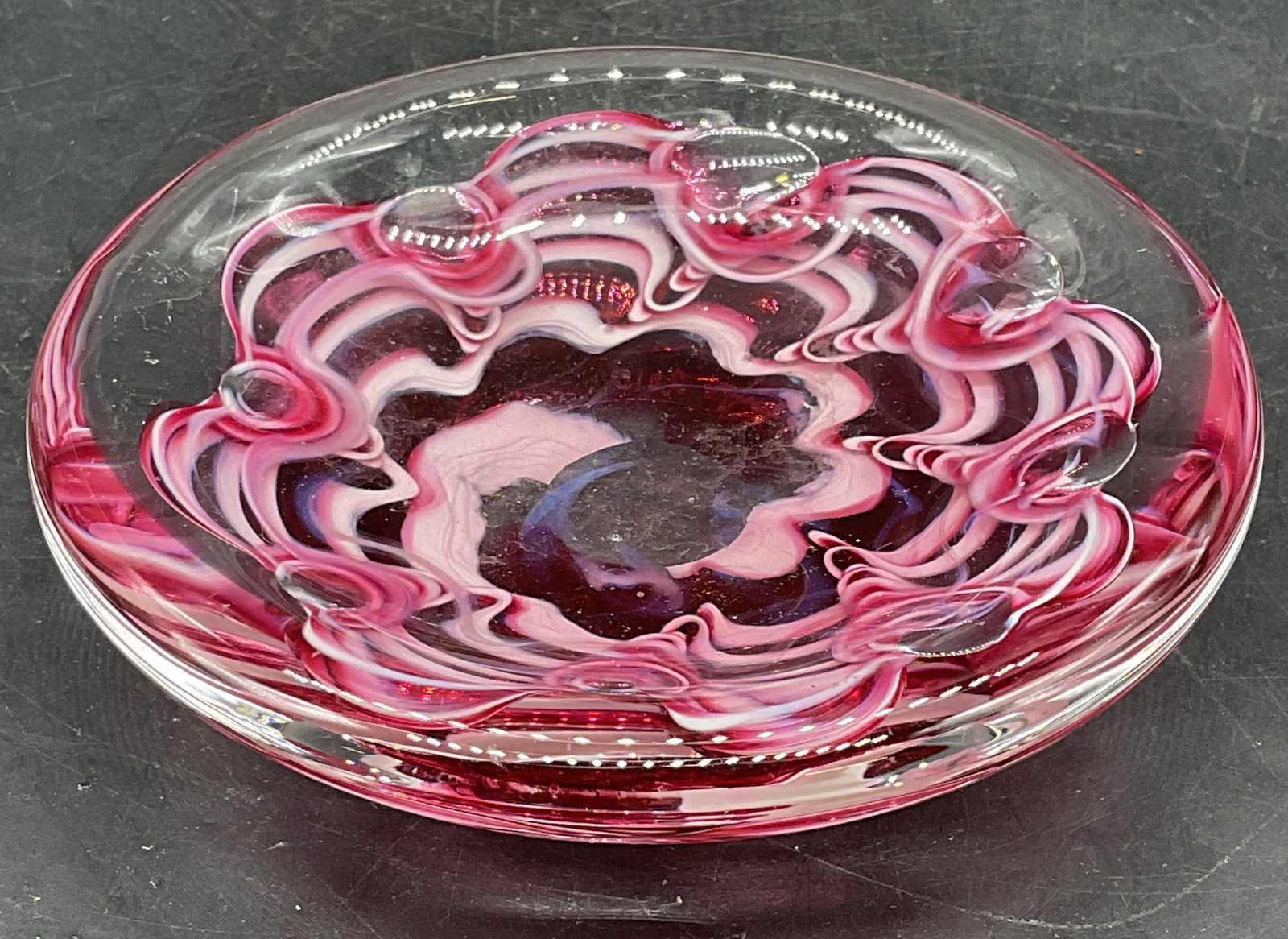Signed Art Glass Pink Swirl Flower Bowl: Signed hand blown art glass bowl with pink swirled flower motif. Signed illegibly. Measures approx. 5 x 1.25 inches. Thick glass, piece has weight. Some scratching. Art glass bowl, collectibles, home 