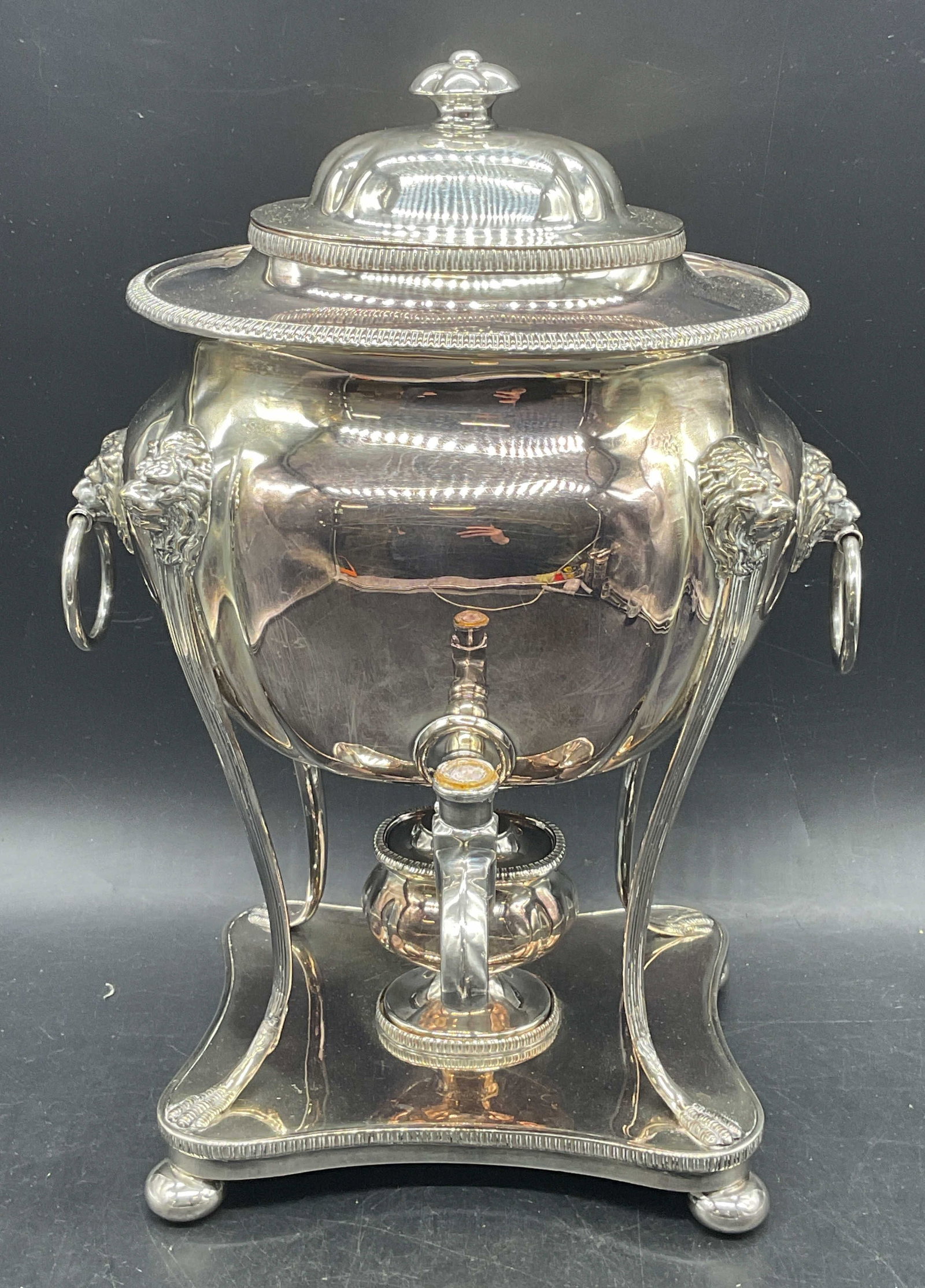 English Silver Plate Lion Hot Water Urn Samovar: English silver plated hot warm urn or samovar. Raised lion head motifs. Marked Sheffield, England on lid. Measures approx. 8.5 x 9 x 13 inches. Piece had weight. Some pieces need replacement. Some scr