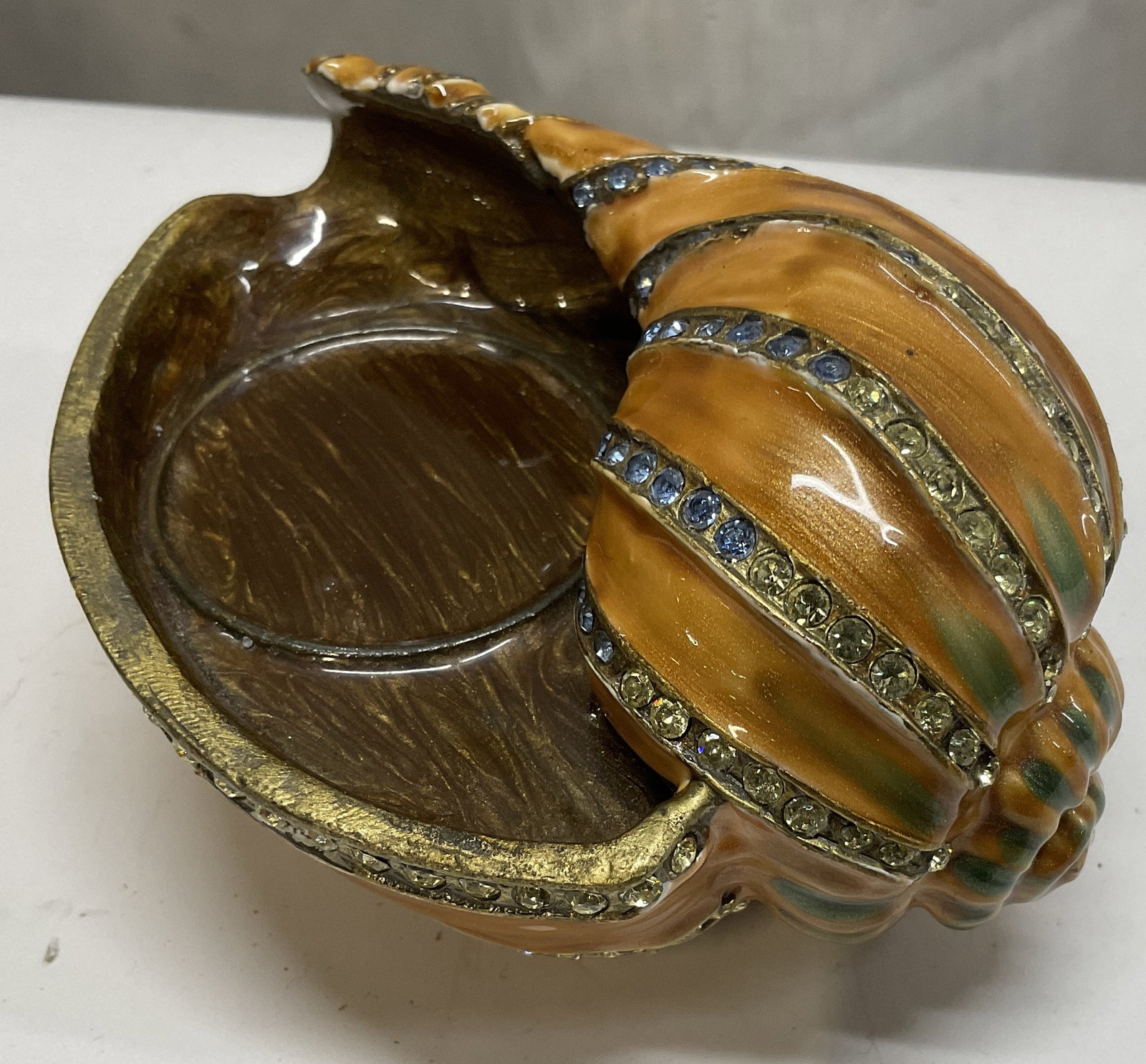 Nicky Enameled&Bejeweled Conch Shell Jewelry Tray: Nicky Enameled and Bejeweled Metal Conch Shell Jewelry Tray. Orange, Blue and Brown Enamel Over Brass Toned Metal with Rhinestone Accents. Circular Indent for Jewelry Inside Shell. Condition Consisten