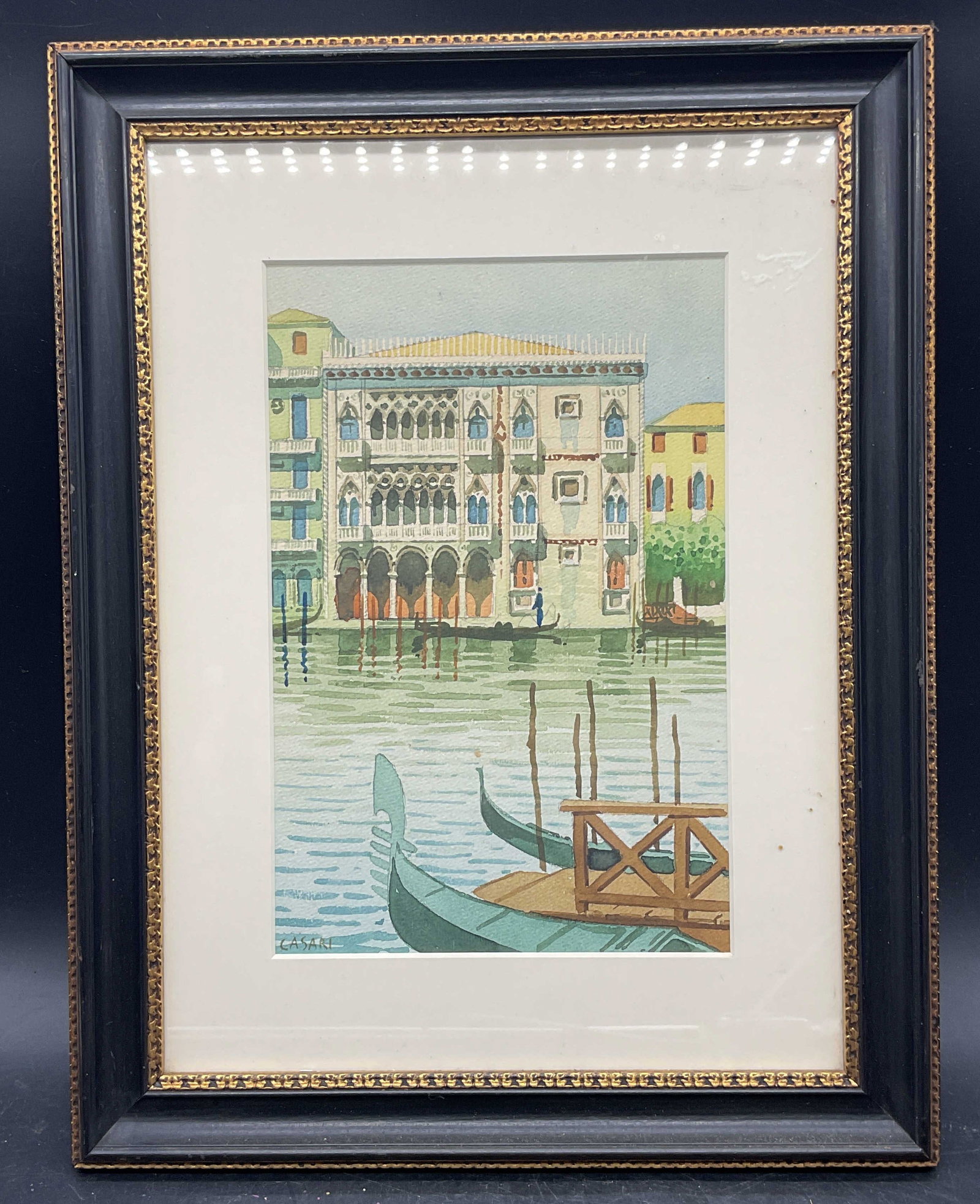 Framed Signed Casari Venice Watercolor Painting: Framed and matted watercolor painting. Signed lower left, Casari. Italian scene, Venice with boats and buildings. Black and gilt wood frame. Not examined out of frame. Frame measures approx. 15.5 x 12